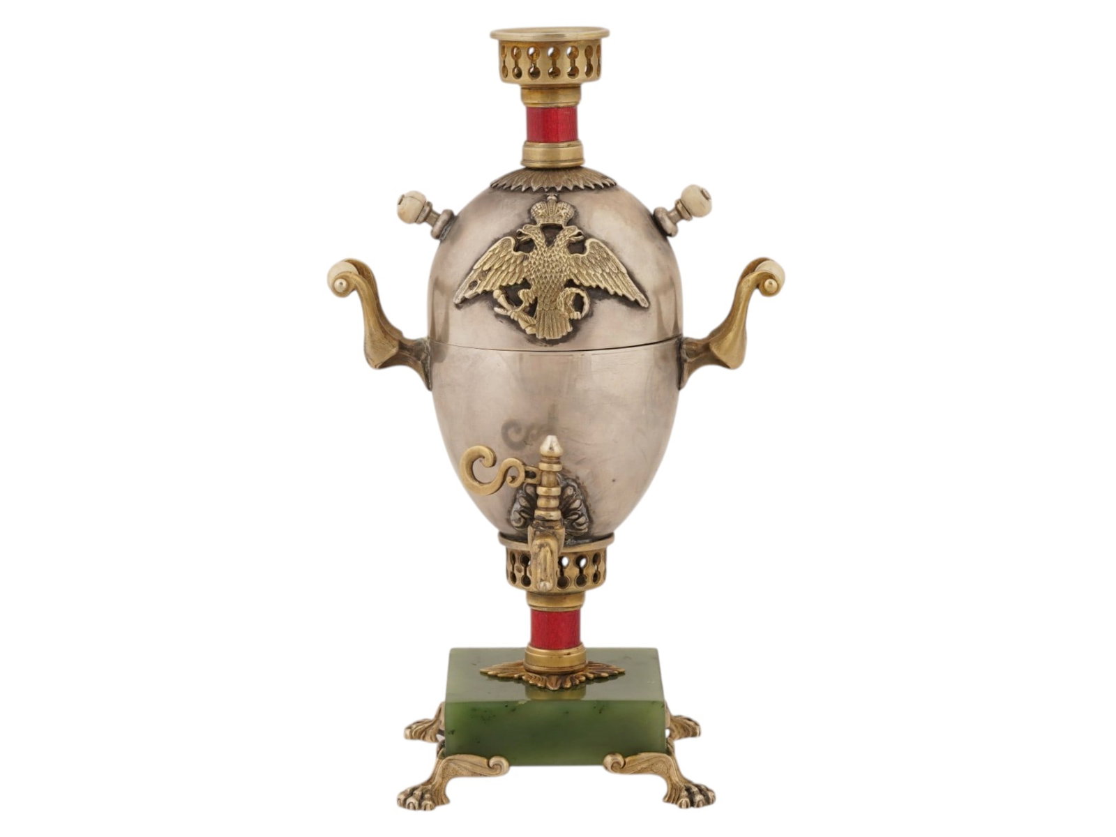 RUSSIAN SILVER ENAMEL SAMOVAR EASTER EGG ON JADE BASE: A miniature Russian silver samovar Easter egg. Consists of two hollow parts, while the upper part has an applied double-headed eagle motif. Some details are carved from natural materials, the upper an