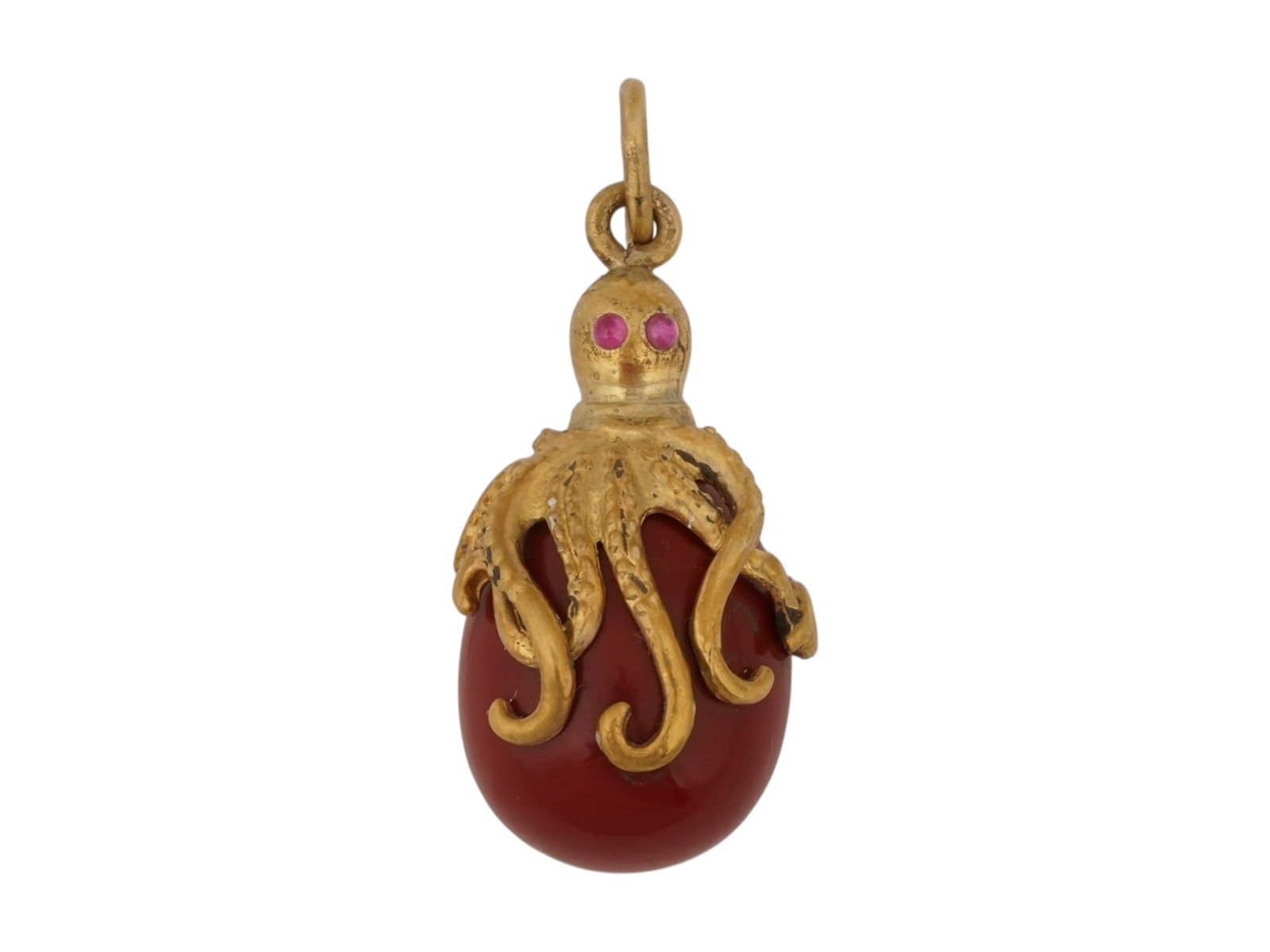 RUSSIAN GILT SILVER JASPER OCTOPUS EASTER EGG PENDANT: A Russian carved jasper Easter egg pendant embraced by an intricately modeled octopus motif. Crafted in gilt silver, the detailed marine figure wraps its tentacles around the polished cabochon and is