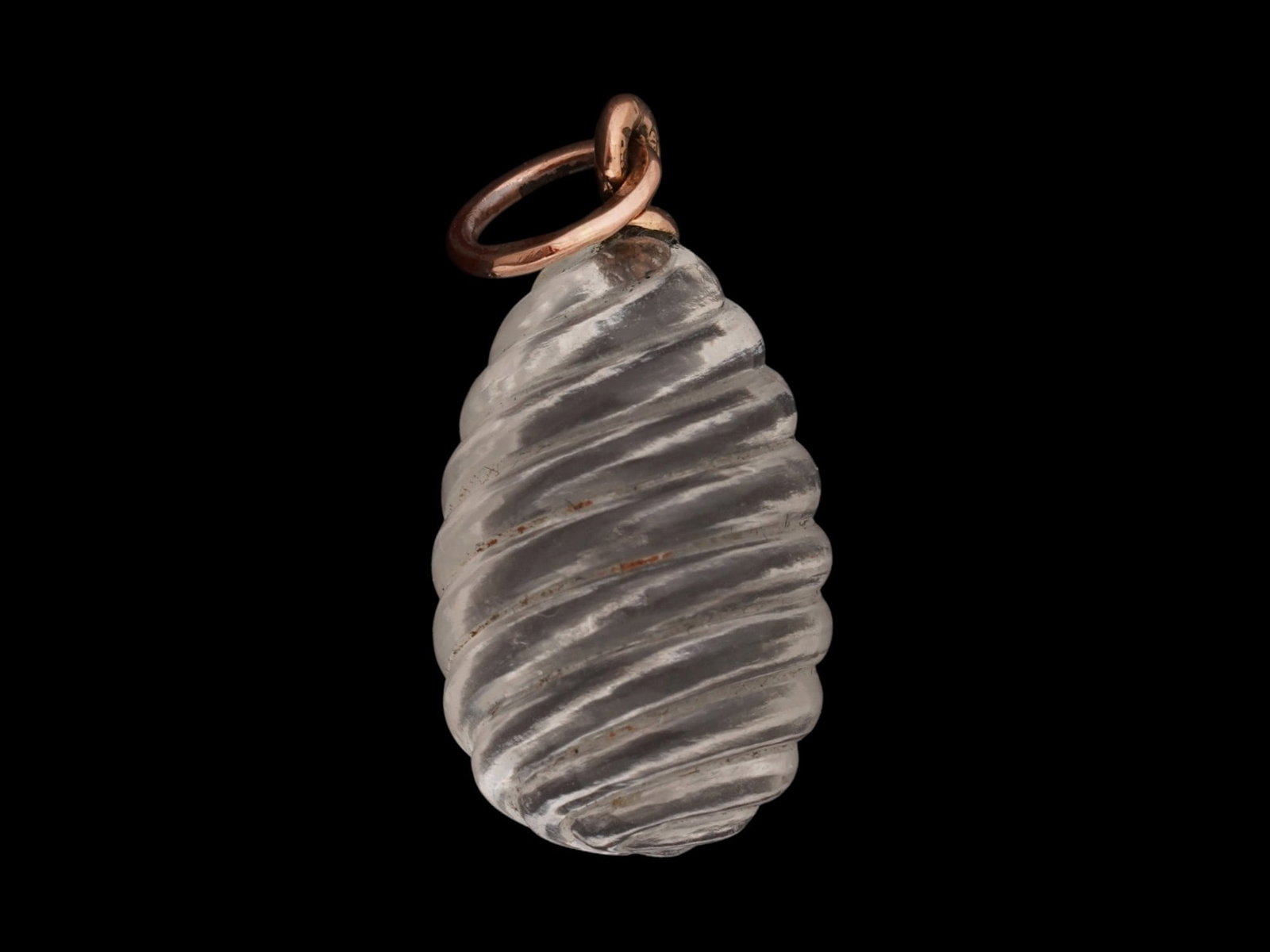 RUSSIAN 14K GOLD CARVED ROCK CRYSTAL EASTER EGG PENDANT: A Russian carved Rock Crystal Easter egg pendant. The pendant is made in a relief ribbed design. Set in 14K gold fittings. Hallmarked to the suspension ring with 56 gold proof and makers marks.