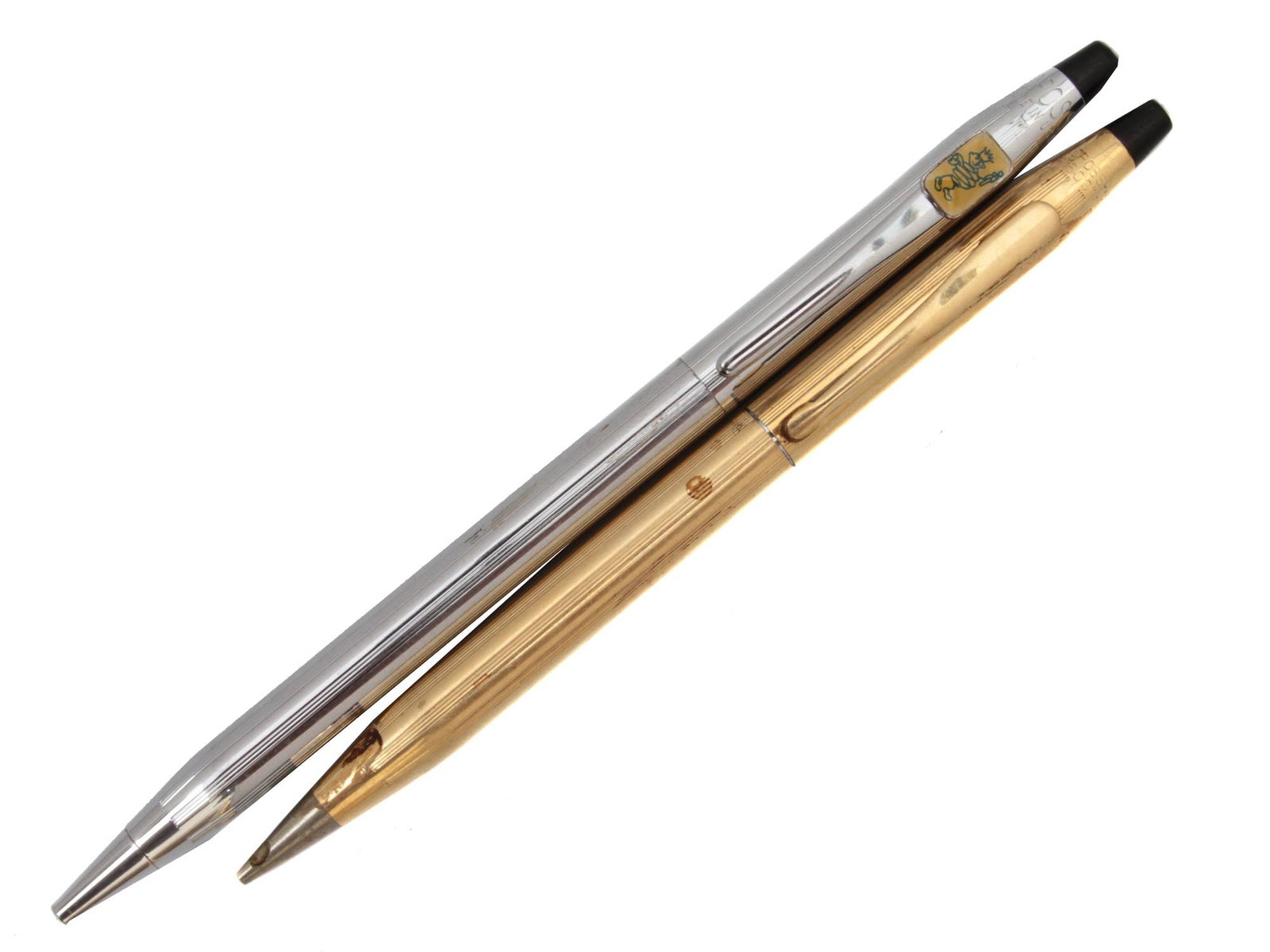 A PAIR OF TWO VINTAGE CROSS BALLPOINT PEN: This set includes:Cross 1/20 12K gold-filled classic ballpoint pen.Cross classic century lustrous chrome ballpoint pen with an emblem. THIS LOT IS ELIGIBLE FOR A 30-DAY UNCONDITIONAL RETURN FROM THE D