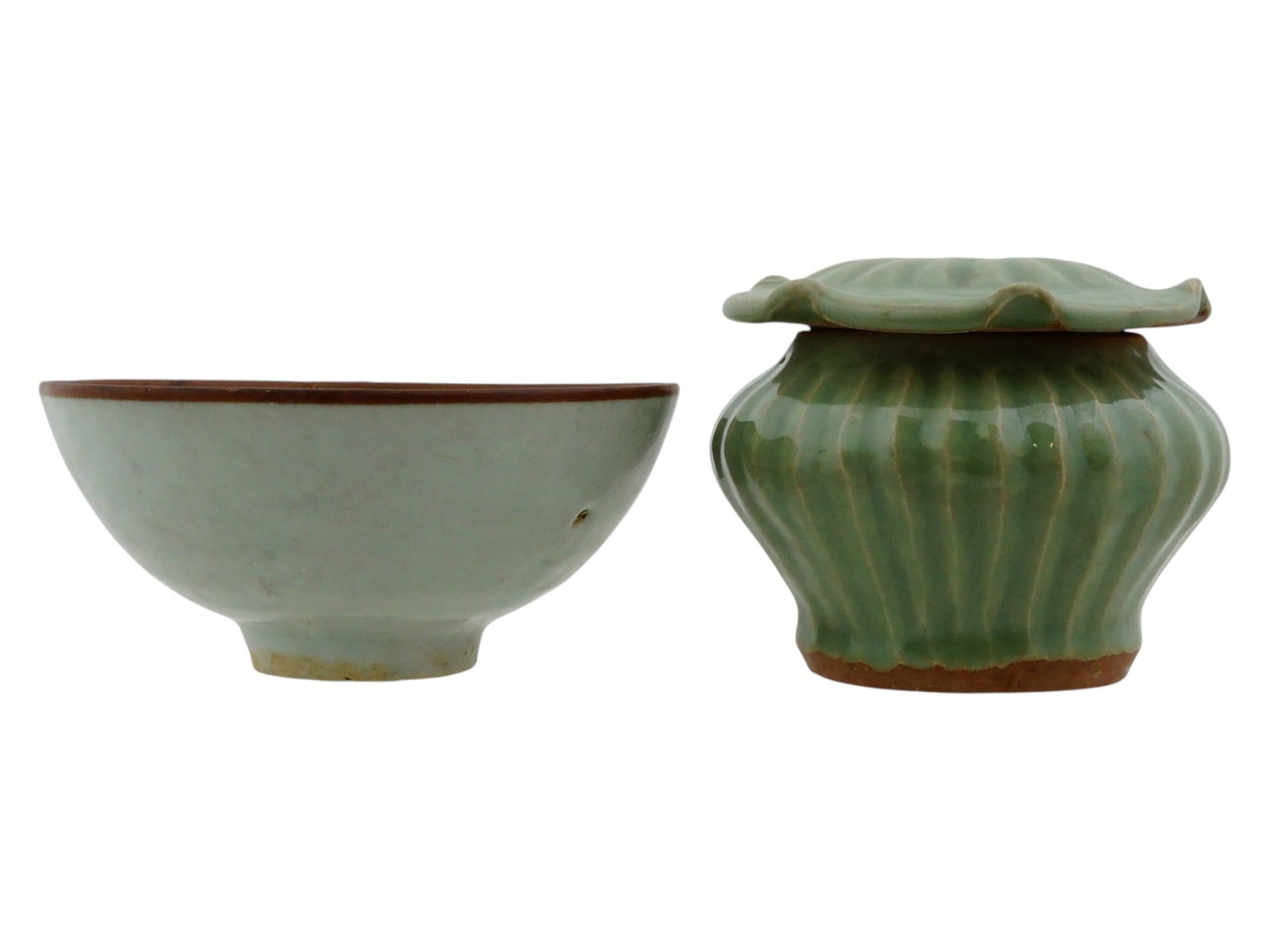 LOT OF TWO CHINESE CELADON GLAZED CERAMIC BOWLS: A lot of two Chinese celadon glazed ceramic vessels or bowls of varying form and finish. The first is a rounded bowl featuring a pale, translucent glaze and a dark pigmented rim, supported by a narrow