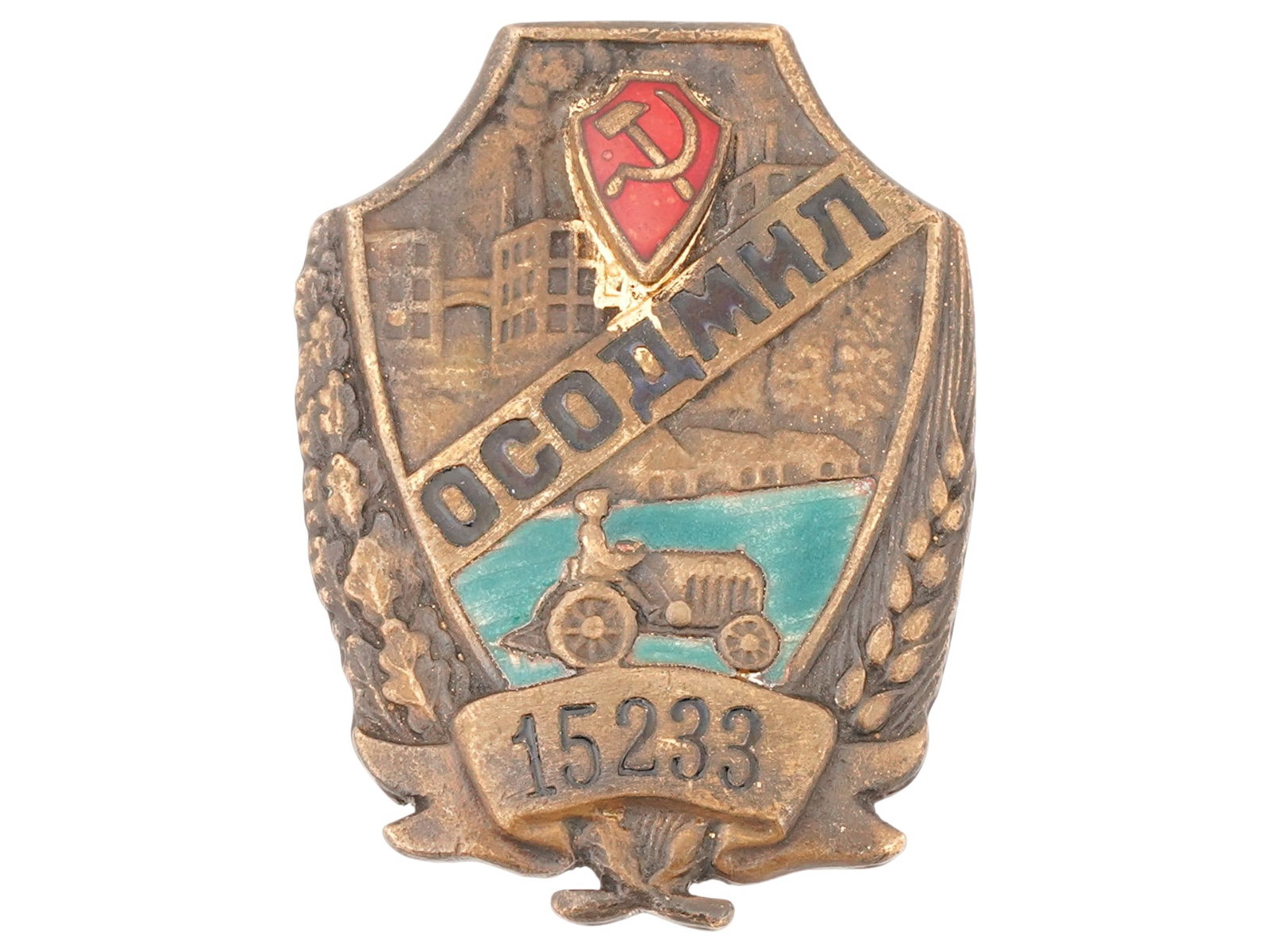 RUSSIAN SOVIET ERA OSODMIL BADGE: A Russian Soviet era badge, OSODMIL society for assistance to police. Circa 1930s. The badge features a red shield with the hammer and sickle symbol, a depiction of industrial buildings in the backgro