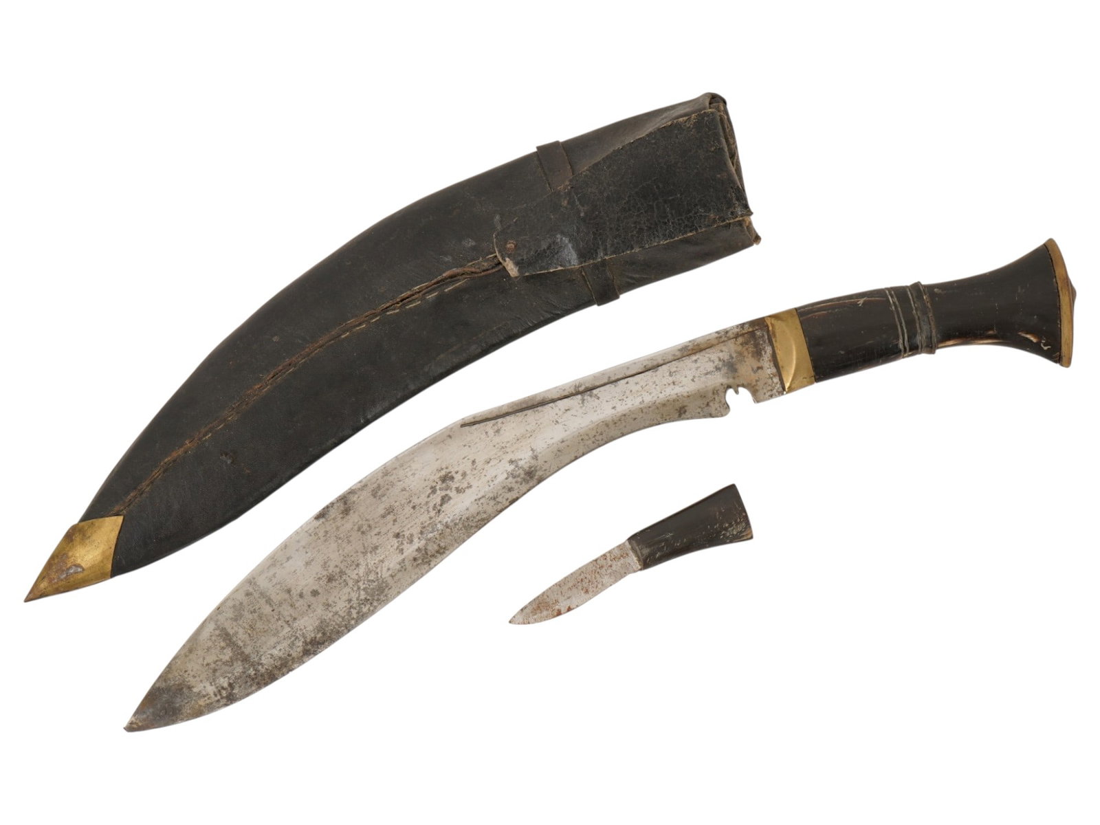 NEPALESE KUKRI KHUKURI KNIFE WITH SCABBARD AND KARDA: A Nepalese kukri features a characteristic recurved steel blade with a prominent notch at the base and a dark carved handle terminating in a metal pommel plate. The set includes a leather-wrapped