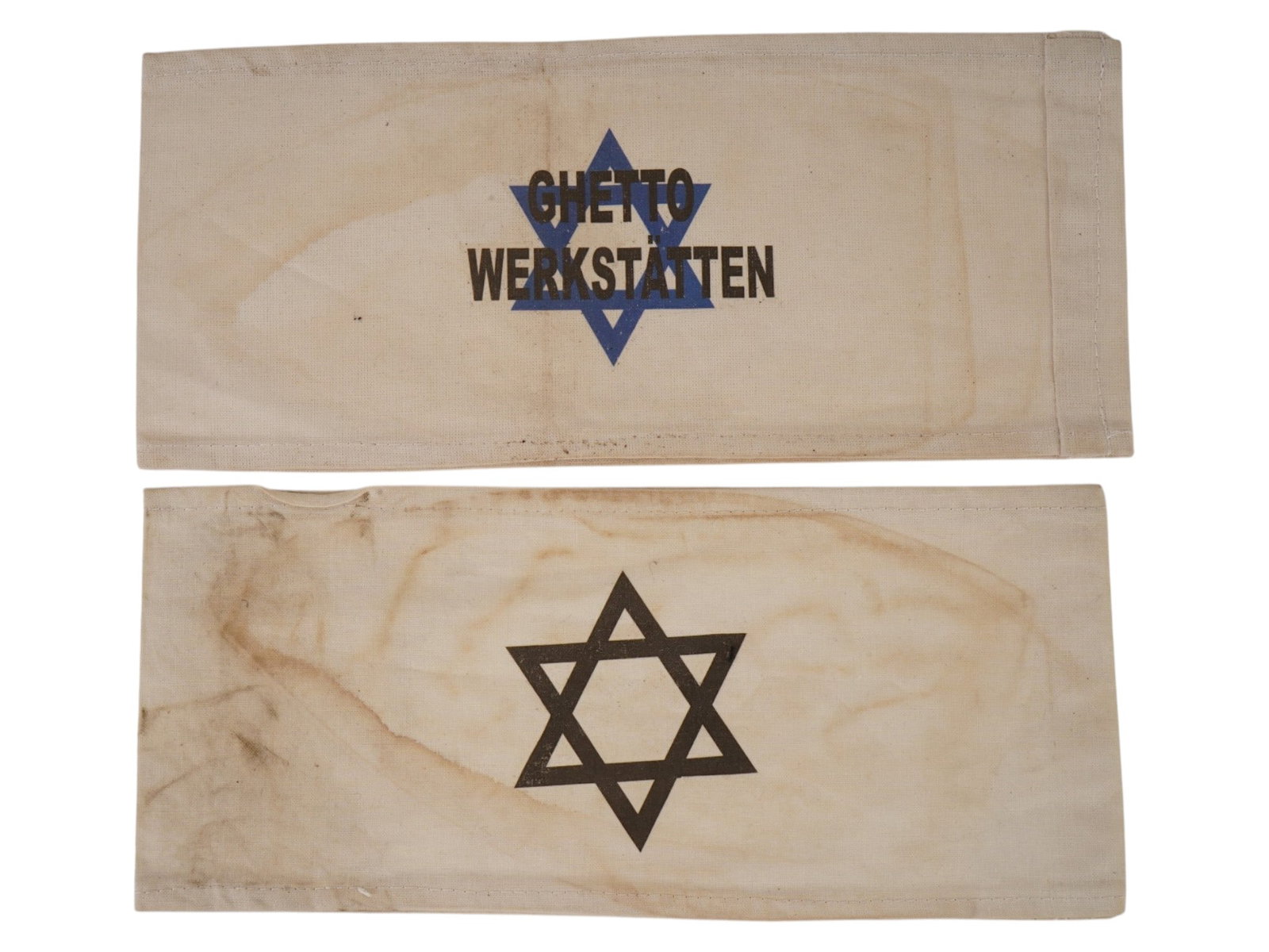 WWII TYPE NAZI GERMAN HOLOCAUST ARMBANDS: Two World War II type Nazi German Holocaust armbands, including an example bearing the Star of David and another with the inscription Ghetto Workshop. These textile artifacts reflect the identificatio