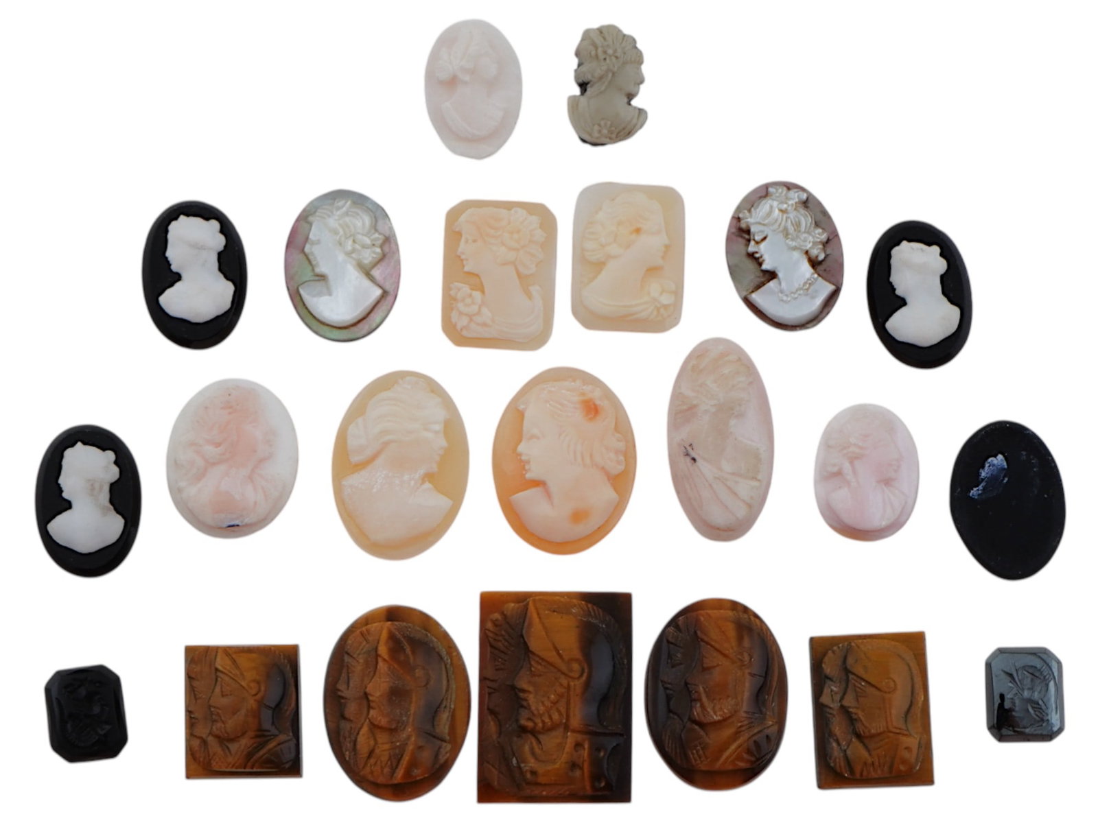 COLLECTION OF ANTIQUE HAND CARVED CAMEOS: A large collection of antique Neoclassical hand carved cameos. Some pieces feature double portraits of warriors, and some feature female portraits. Oval and rectangular shaped. Dating back to the late