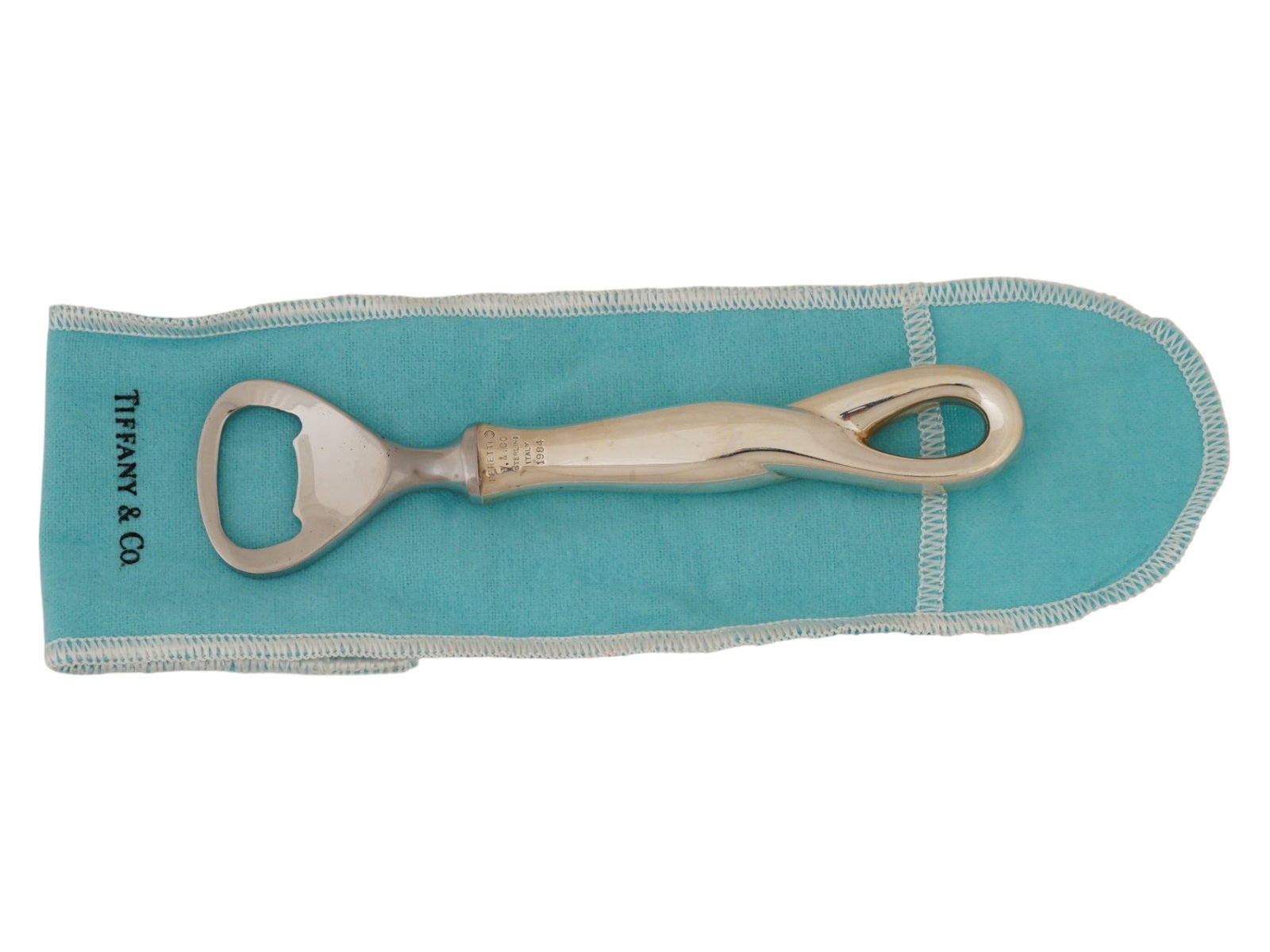 VTG TIFFANY ELSA PERETTI PADOVA SILVER BOTTLE OPENER: A vintage Tiffany and Co. sterling silver and stainless steel bottle opener in the Padova pattern designed by Elsa Peretti in 1984. The piece features a sleek, organically shaped sterling silver