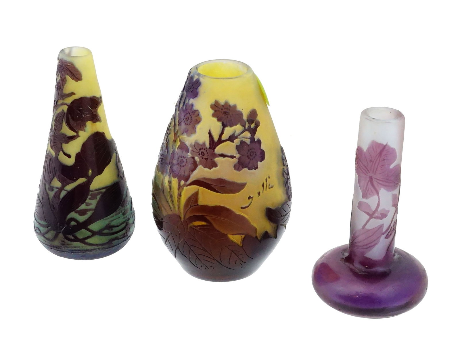 LOT OF THRE SMALL ART NOUVEAU GALLE FLORAL GLASS VASES: A lot of three small Art Nouveau style Galle cameo glass vases, each featuring multi layered glass with acid etched decoration. The collection includes a conical landscape vase with green and amber to