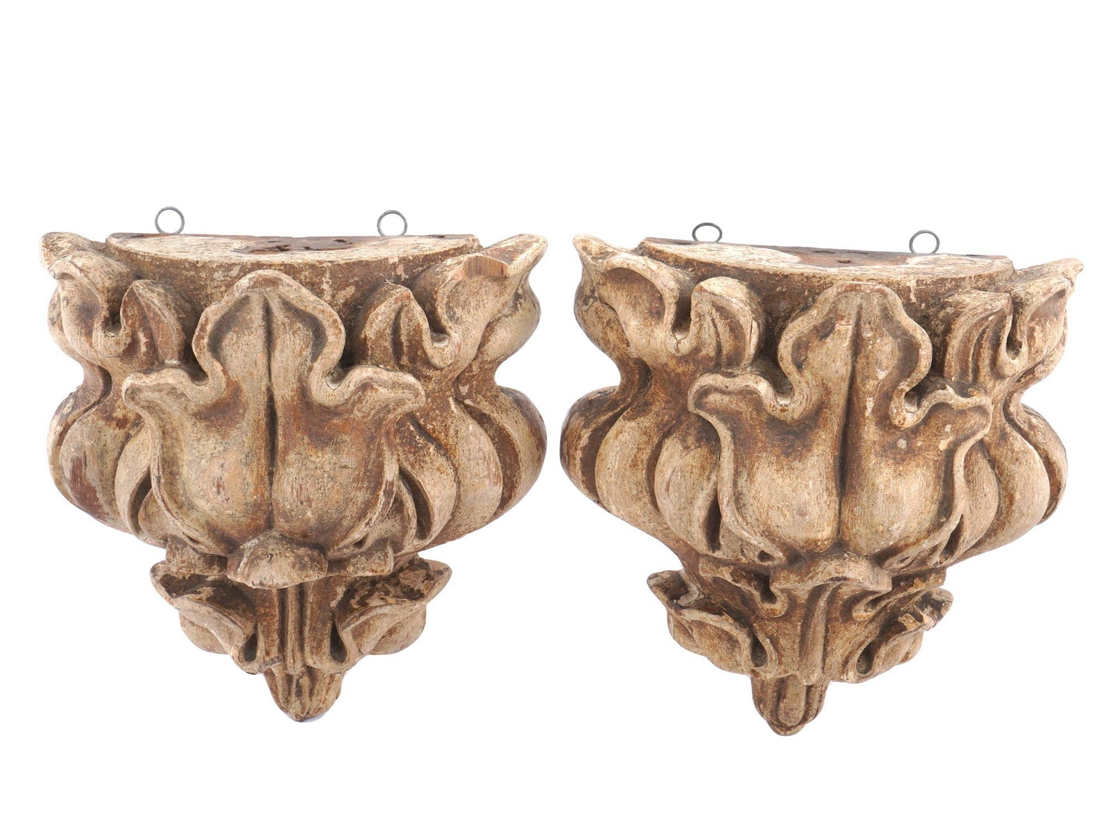 PAIR OF ANTIQUE PAINTED WOODEN WALL BRACKETS: A pair of antique painted wooden wall brackets with relief floral designs. Circa the first half of the 20th century. Flat tops. Each item has two hanging rings for attaching to the wall. Collectible W