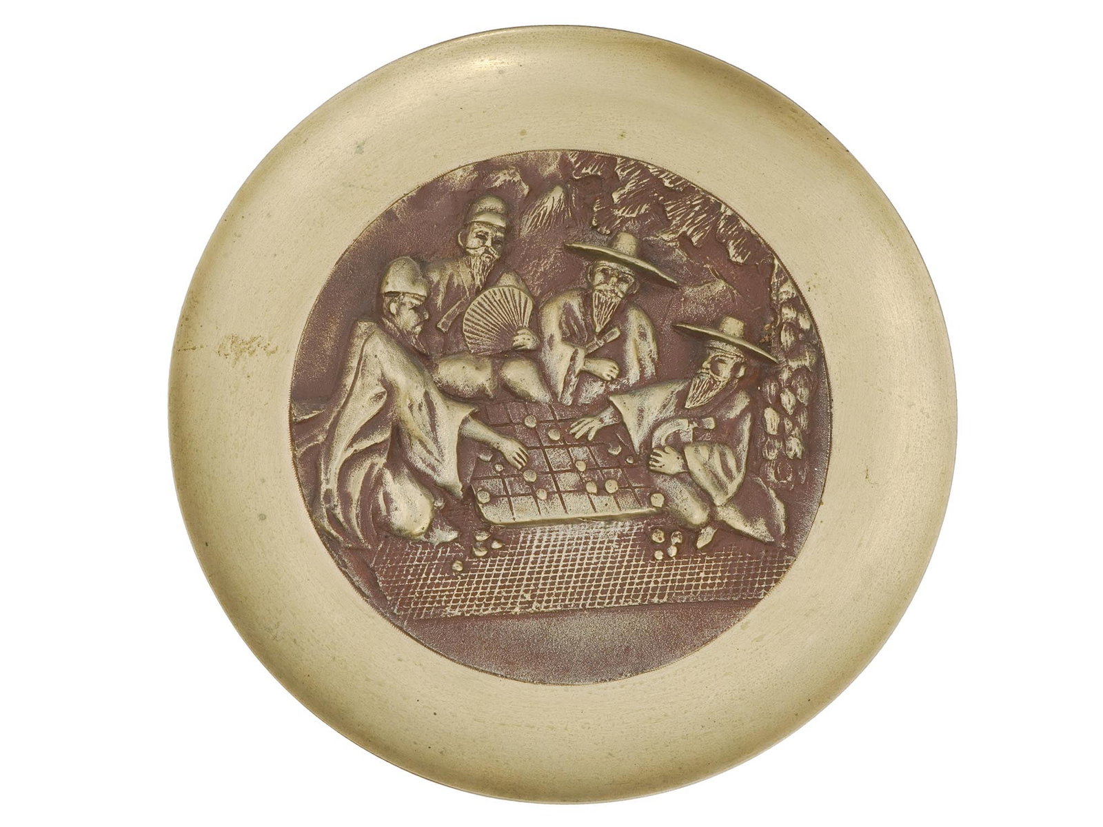 CHINESE WALL PLATE W PEOPLE PLAYING TABLE GAME: A vintage Chinese bronze and brass wall plate with people playing a table game. Circa 1960s. A round plate with a relief scene of the Chinese board game Go, with two elderly men playing and two watchi