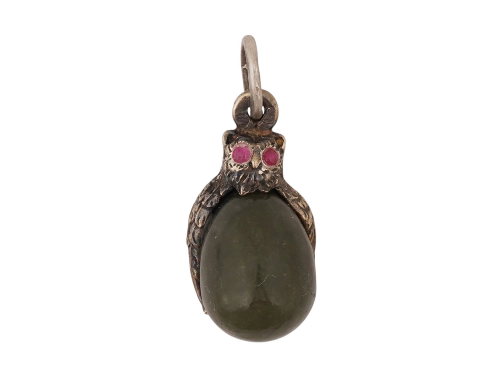 RUSSIAN SILVER JADE OWL EASTER EGG PENDANT W RUBY EYES: A Russian 84 gilt Silver and hand carved Jade Easter egg pendant. The pendant is adorned with a gilt Silver mount on top modeled as an owl with wings, engraved with detailed patterns. The owl is encru