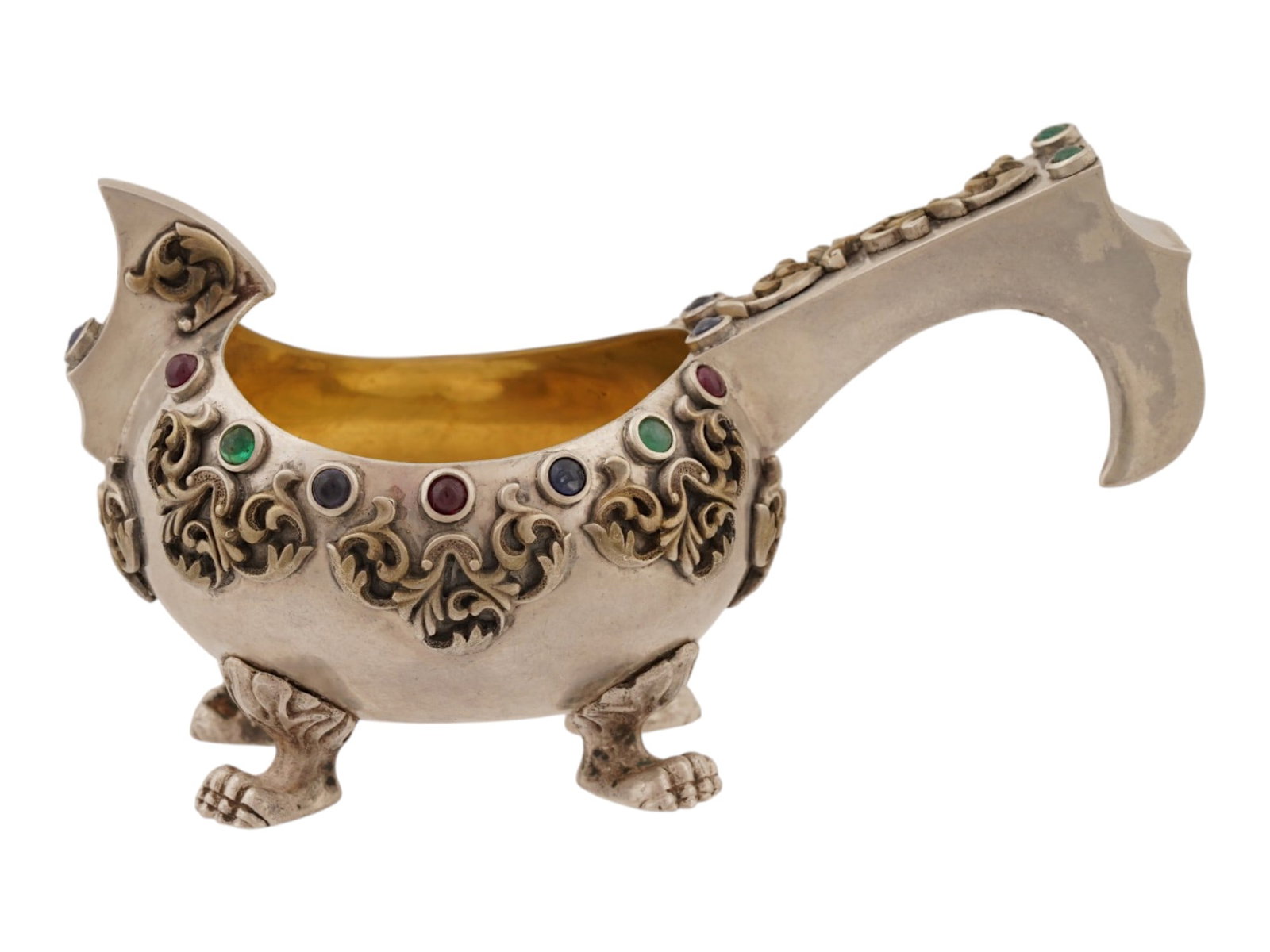 RUSSIAN SILVER GEMSTONE KOVSH LADLE: A Russian silver kovsh, a traditional oval-shaped drinking vessel or ladle with a single handle. Rounded piece with hooked handle. The piece rests on four paw feet and is garnished with gemstone caboc