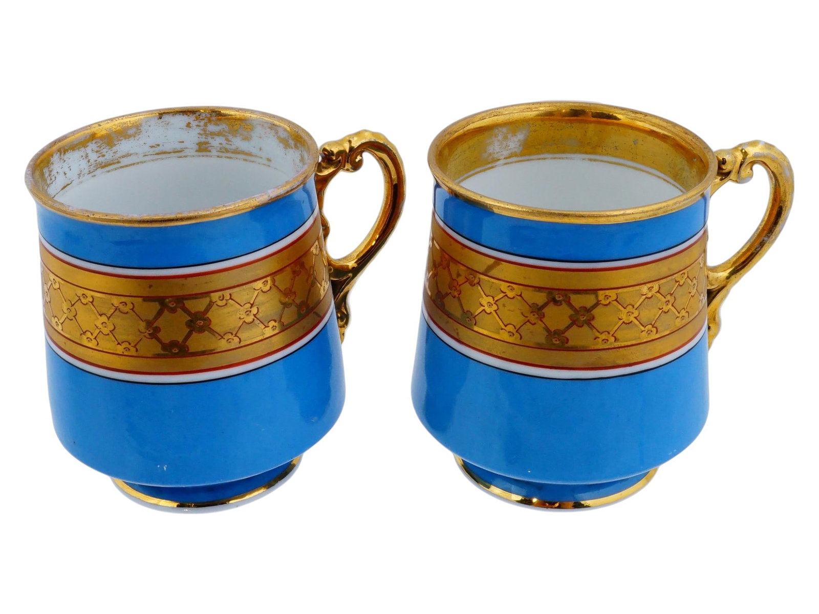 ANTIQUE RUSSIAN GARDNER BLUE PORCELAIN TEA CUPS: A pair of antique 19th century Russian porcelain tea cups. The cups are decorated with an ornamental gilt pattern on a blue ground. The wares are adorned with gilded curved handles and gilded rims. Ma