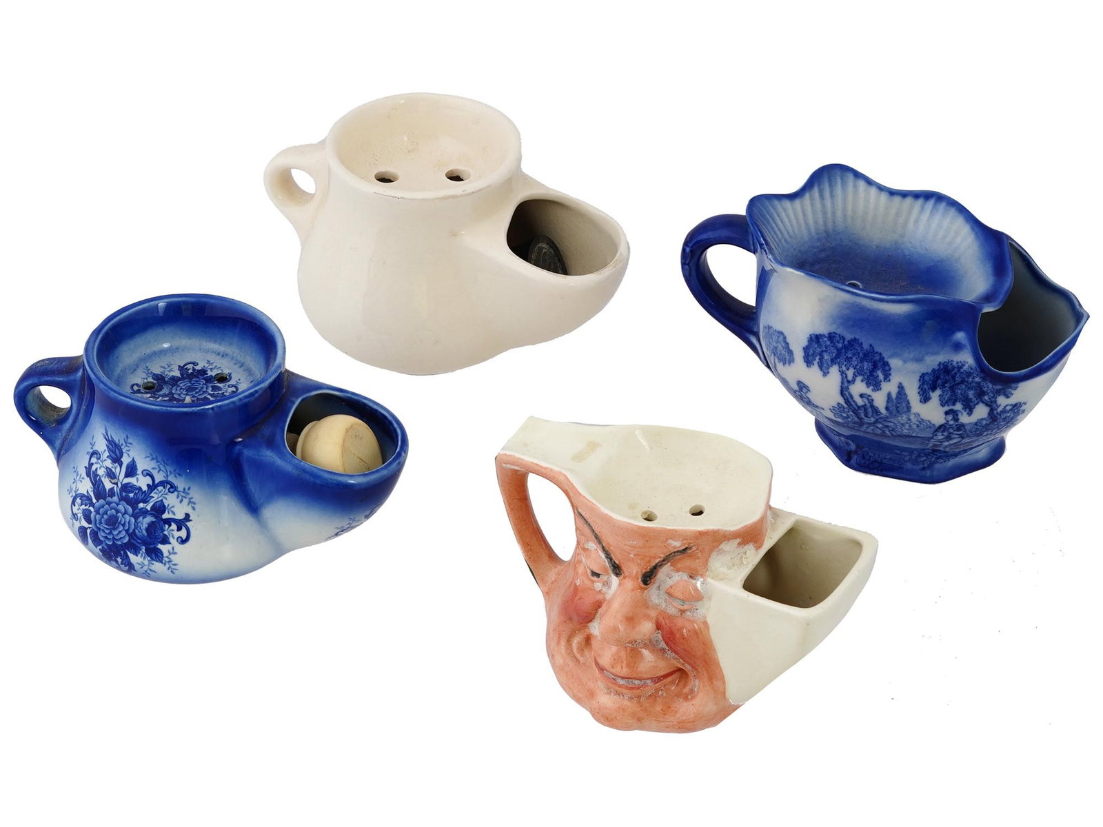 VINTAGE ENGLISH IRONSTONE STAFFORDSHIRE SHAVING MUGS: A lot of four vintage English Ironstone Staffordshire shaving mugs. The lot includes a mug with a horse hunting scene. Two blue ones with a floral pattern and a landscape. One figured humorous double 
