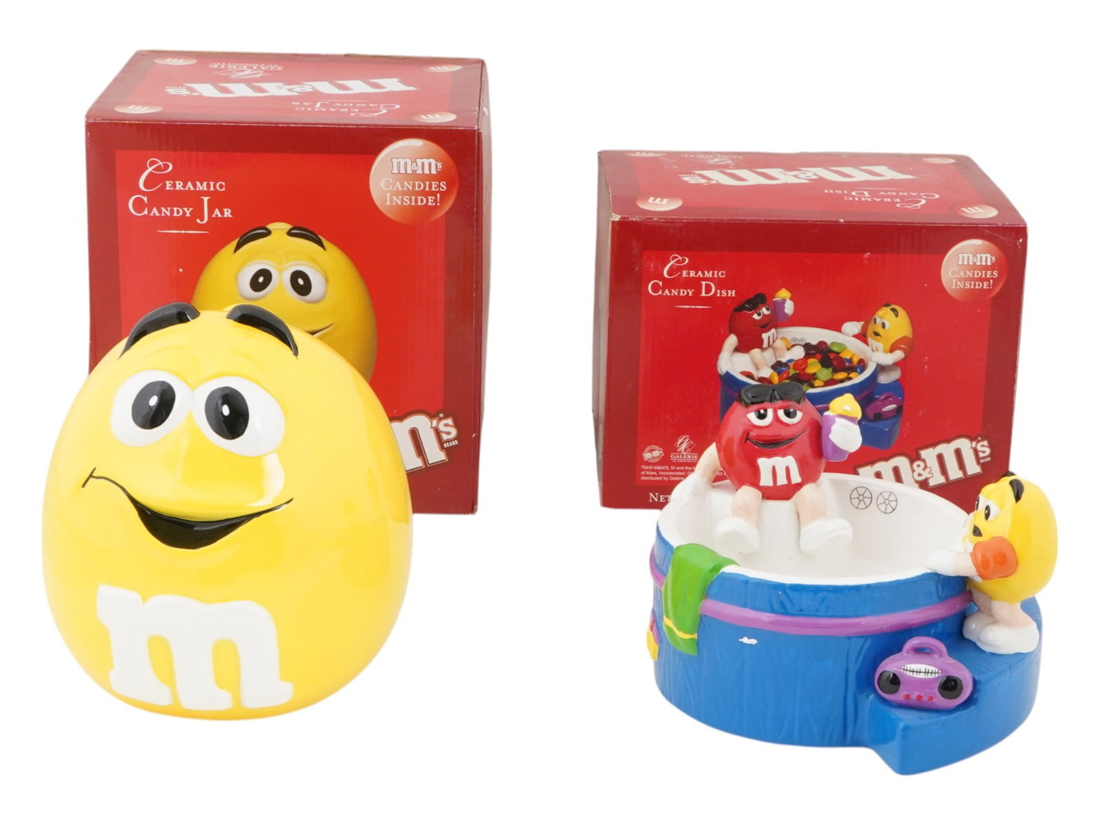 LOT OF TWO M AND MS GALERIE COLLECTION COOKIE JARS: A lot of two M and Ms Galerie collection cookie jars including a Hot Tub Ceramic Candy Dish and a jar with lid, each with its original packaging. One features a yellow M and Ms character, the other de