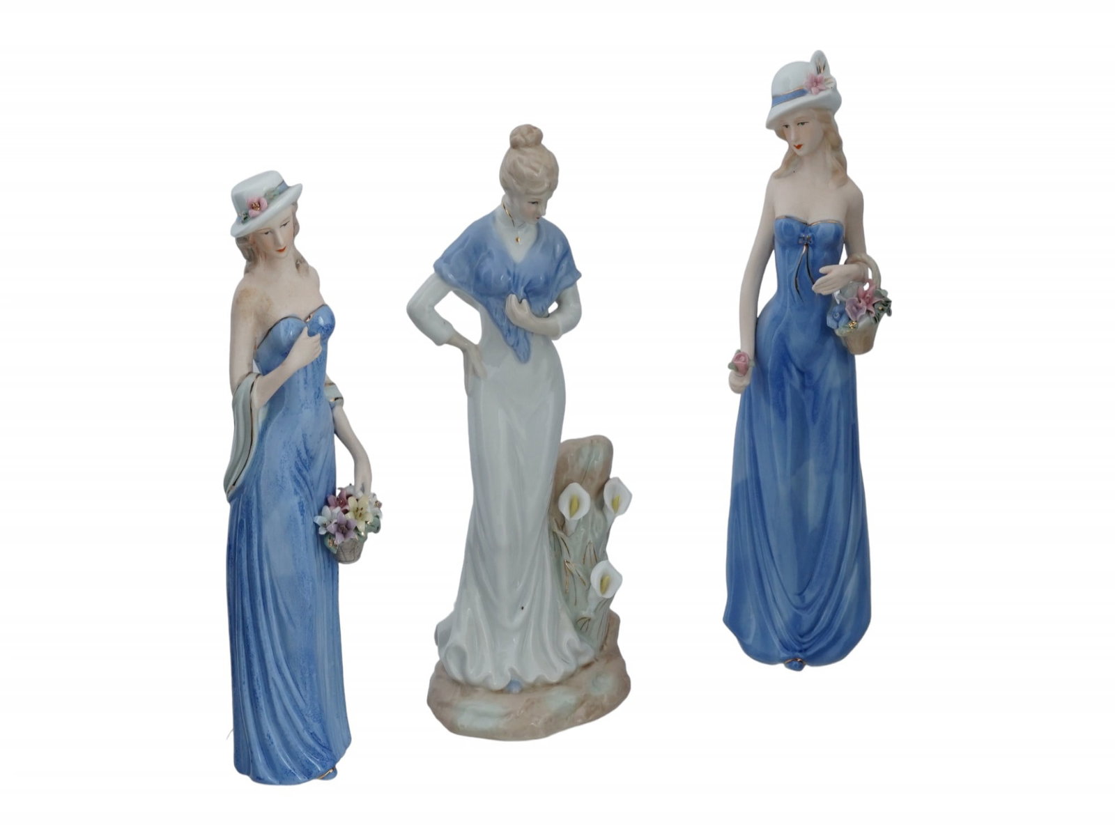 LARGE VINTAGE GLAZED PORCELAIN FEMALE FIGURINES: A lot of three large vintage glazed porcelain figurines. Two matching pieces representing a young woman in blue dress with a flower basket, unmarked. A figurine of a woman in white dress with lilies, 