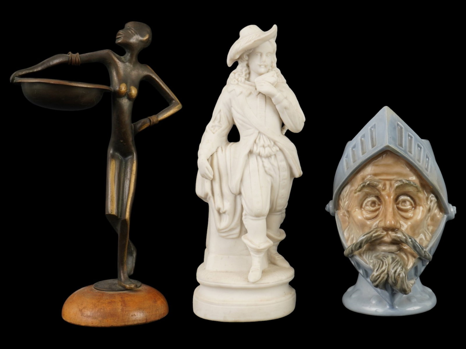 GROUP OF THREE FIGURINES ISRAELI BRONZE AND CERAMIC: A group of three pieces features a modern Israeli bronze figure of a stylized bearer holding a tray, mounted upon a polished circular wooden base. Accompanying the bronze is a white bisque ceramic fig