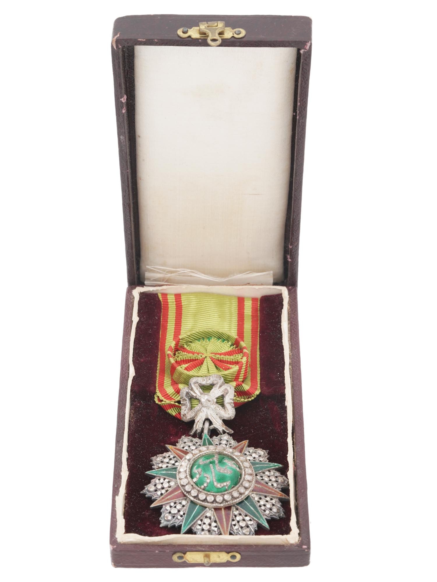 ANTIQUE TUNISIAN SILVER GLORY ORDER OFFICER BADGE: An antique Tunisian Order of Glory officer badge in silver with red and green enamels. With the cipher of Muhammad V an Nasir, 1906 to 1922, on the centerpiece. With the original ribbon. Founded in 18