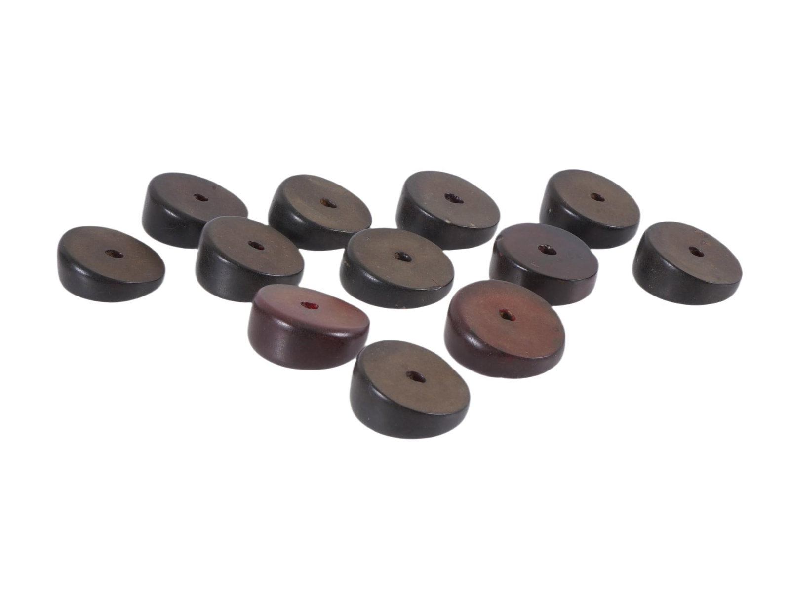 COLLECTION OF 12 HAND CARVED WOODEN BEADS: A collection of 12 hand carved wooden beads. Round beads with a smooth surface and a hole in the middle. One edge of each bead is raised. Vintage and Modern Carved Wood Beads, Accessories, and Collect
