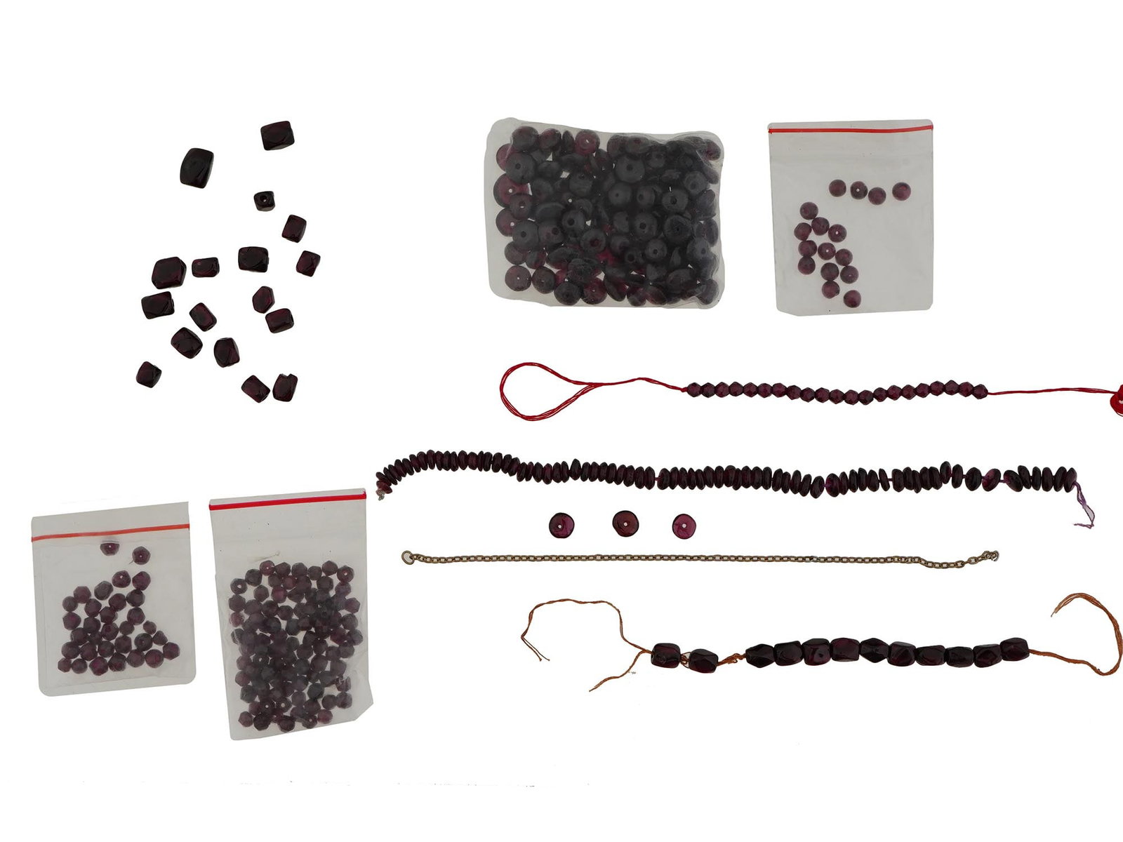 COLLECTION OF GARNET STONE BEADS F JEWELRY DESIGNS: A collection of assorted garnet stone beads features an array of natural deep red tones in various shapes and forms. Some beads are sorted into packages and ready to be used in creating elegant costum