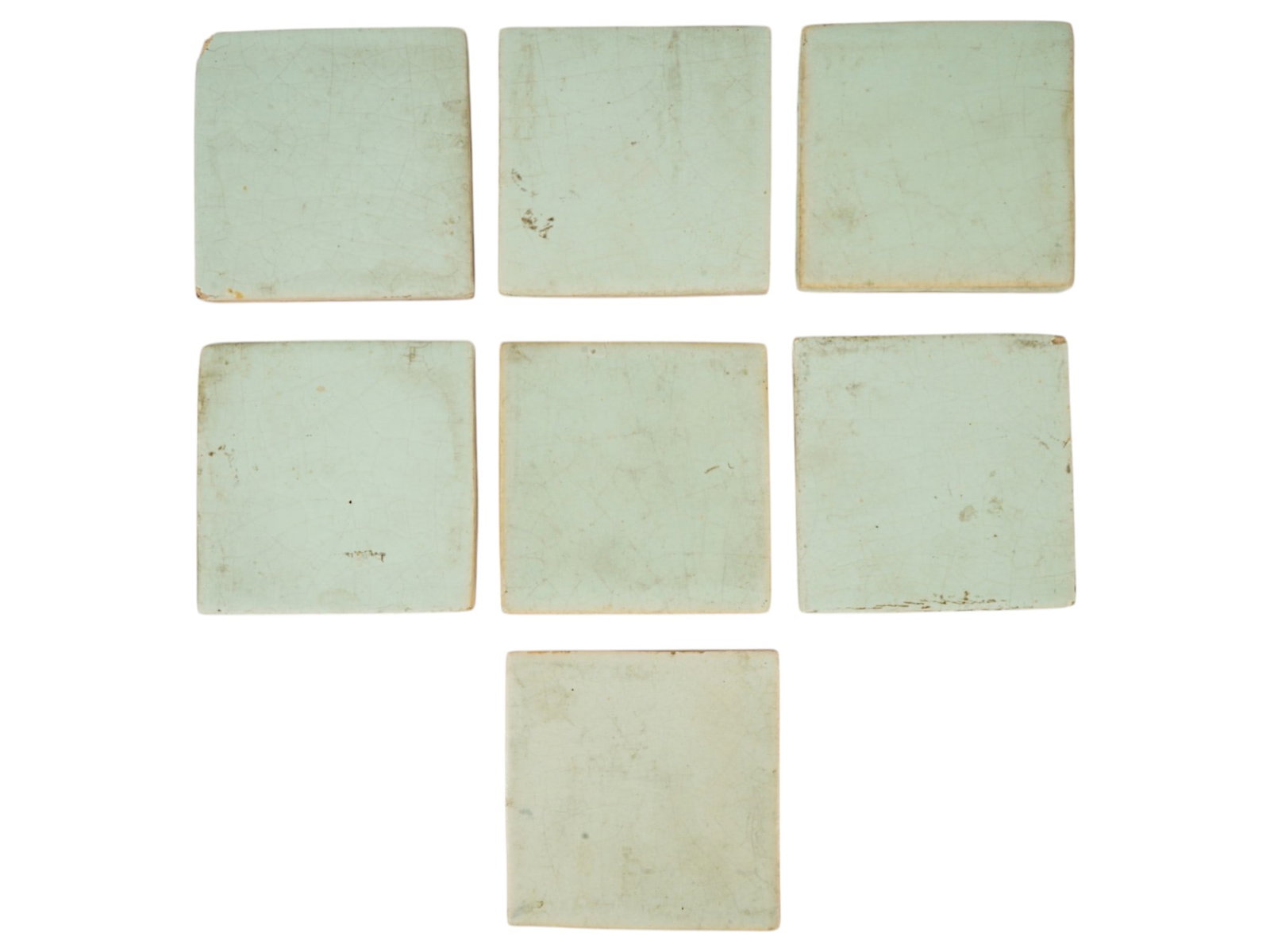AMERICAN ARTS AND CRAFTS CERAMIC TILES ATTR TO GRUEBY: A group of seven square ceramic tiles from the American Arts and Crafts movement, featuring a matte pale blue glaze. Attributed to the Grueby Faience Company. Grueby was a prominent American producer 