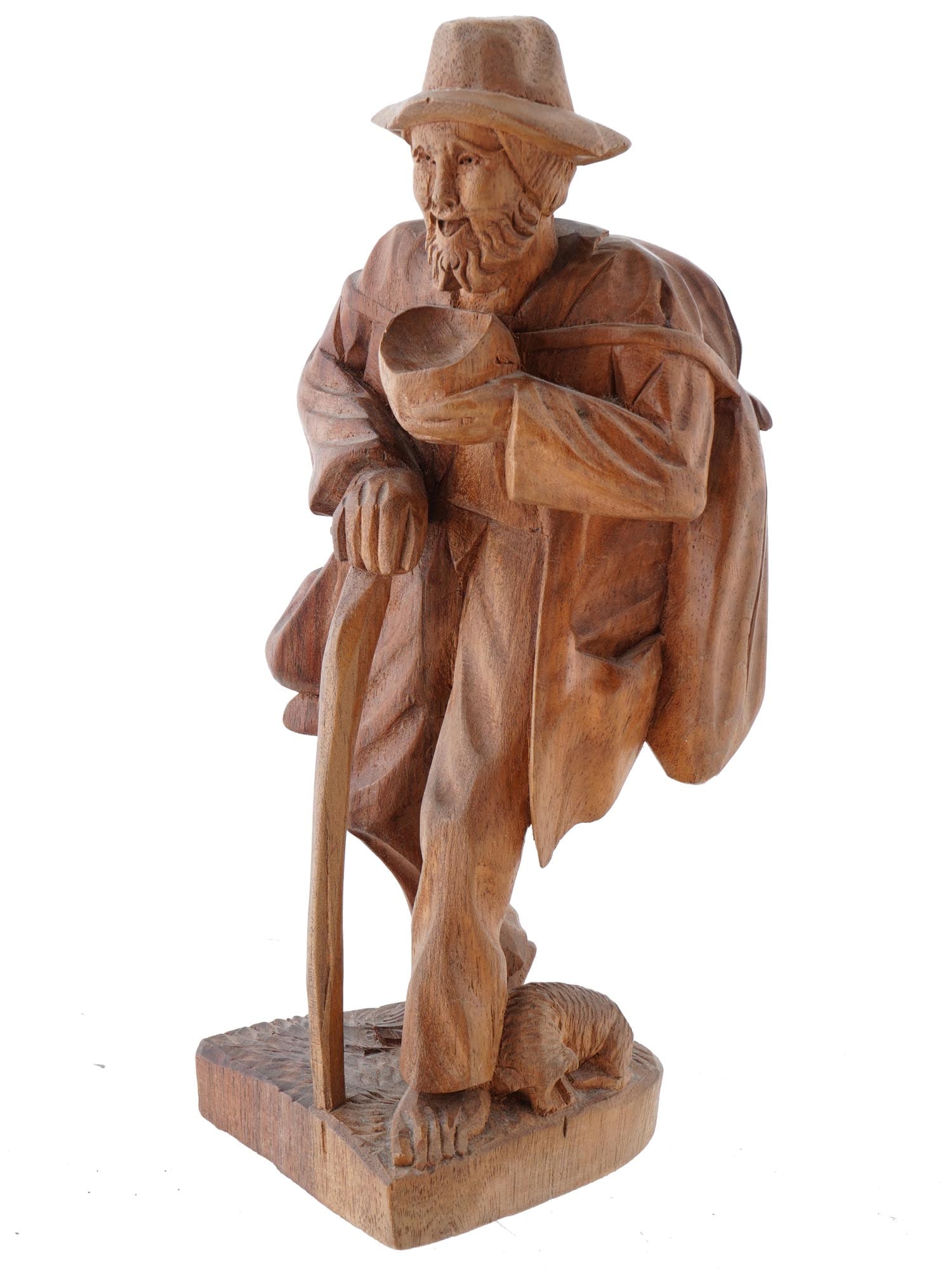 FOLK ART HAND CARVED WOODEN FIGURINE OF TRAVEL MAN: A vintage Folk Art hand carved wooden figurine. The figurine depicts a traveling old man holding a bowl in in his left hand and a cane in his right; and a dog near his feet. Mounted on a carved wood b
