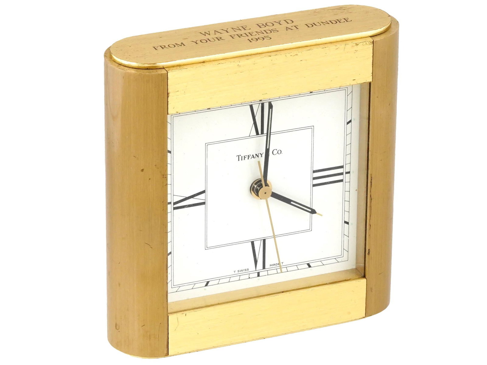 VINTAGE AMERICAN TIFFANY AND CO BRASS DESK CLOCK: A vintage American Tiffany and Co. Swiss made desk clock. The clock is set in a square, heavy brass case that exudes timeless elegance. Its white dial is adorned with black Roman numerals, creating a 