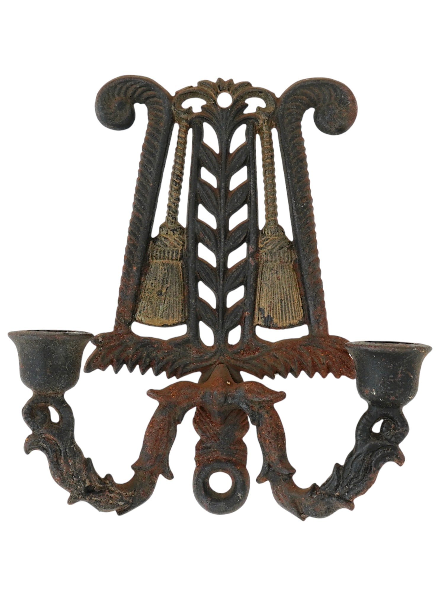 ANTIQUE AMERICAN CAST IRON WALL SCONCE BY WILTON: An antique American cast iron wall sconce for two candles with gold tone elements produced by Wilton. Colonial style candle holders with openwork design featuring tassel and foliage motifs. Round open