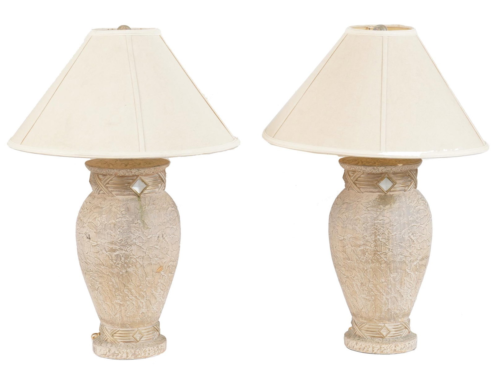PAIR OF VINTAGE TABLE LAMPS WITH CREAM SHADES: A pair of elegant vintage table lamps with baluster shaped textured bodies painted in gold and decorated with white diamond shaped inserts. Feature cream fabric shades. Unmarked. Dated circa the secon