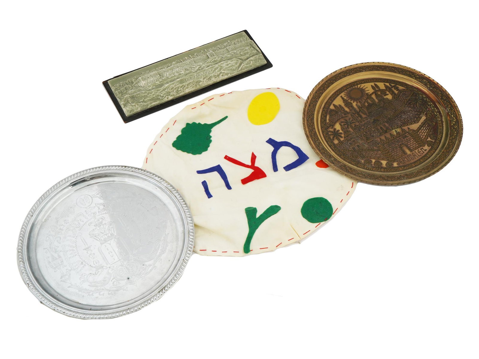 VINTAGE COLLECTION OF DIFFERENT JUDAICA ITEMS: A lot of three Judaica items. A silver tray: This is a round, silver tray, likely used for serving foods during the Passover seder. It has a smooth, polished surface and has a delicate engraved design