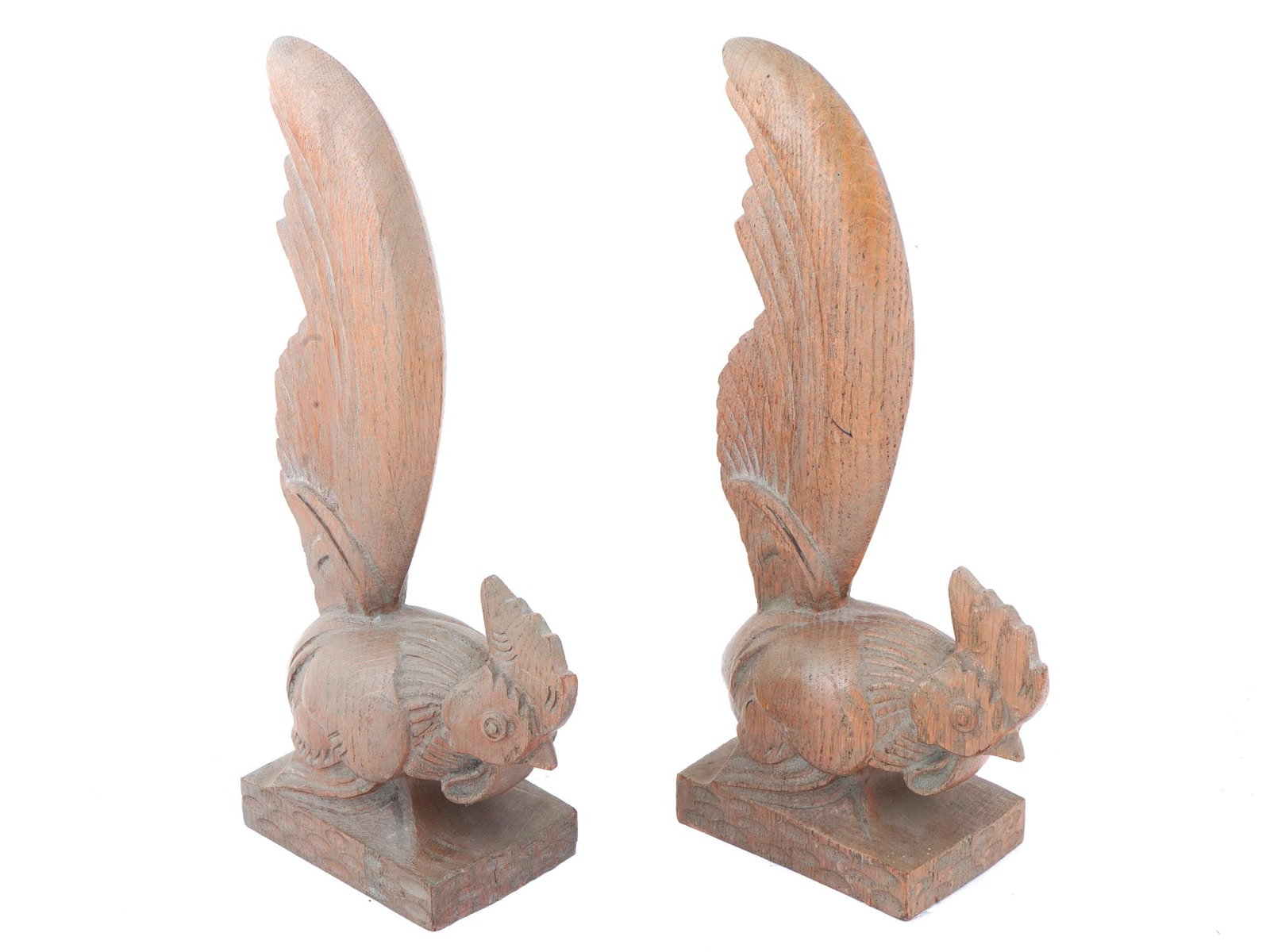 PAIR OF VINTAGE WOODEN ROOSTER BOOKENDS FIGURINES: A pair of vintage wooden rooster bookends figurines executed in fine detailing. Roosters stand on their feet with tails held high and heads bowed low. Circa the late 20th century. Marked KarvedWood Co