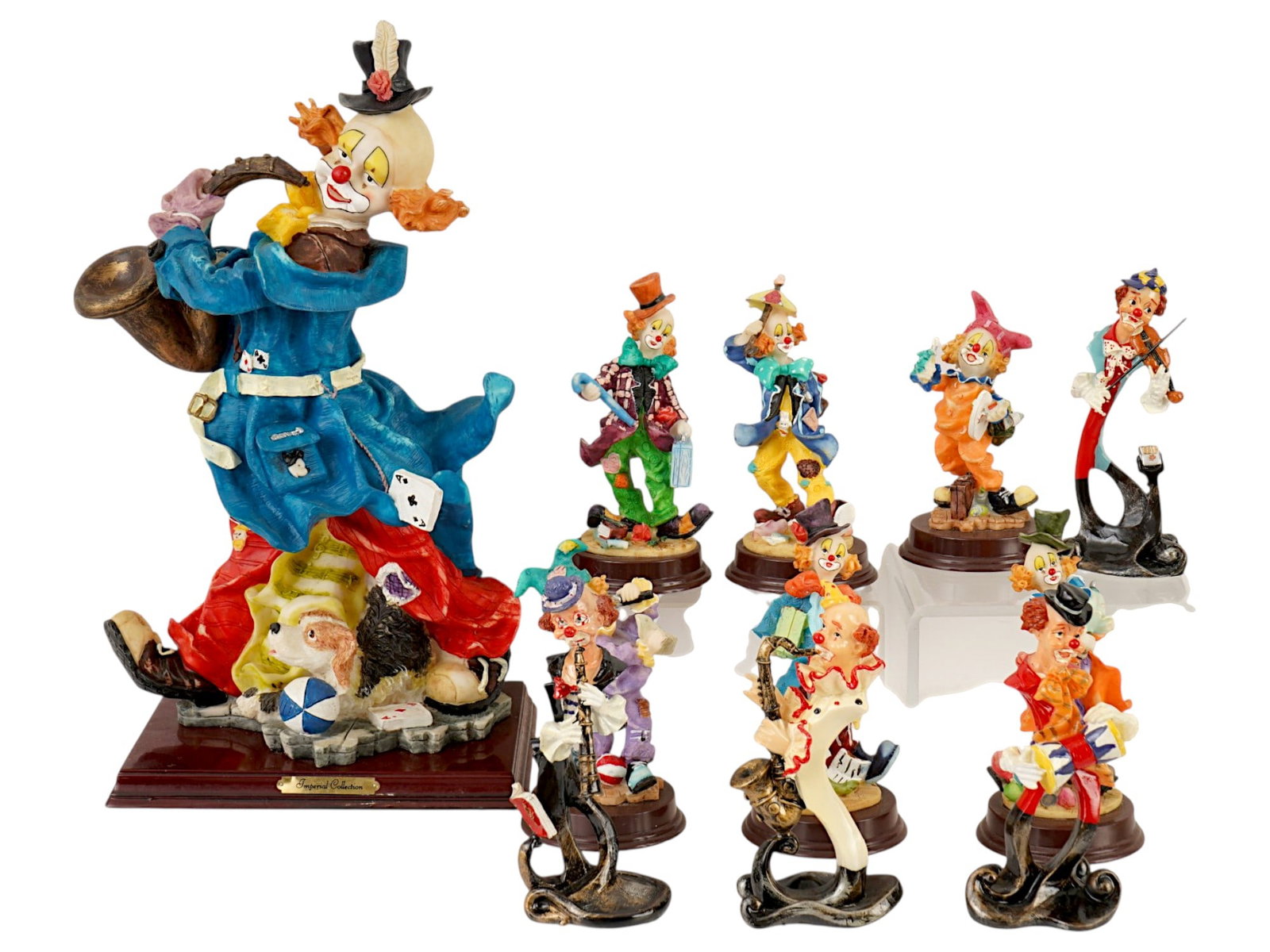 GROUP OF 11 KS COLLECTION RESIN CLOWN FIGURINES: A group of 11 Ks Collection resin clown figurines. The lot includes 10 small figurines and one large one, all featuring vibrant colors and dynamic poses. All have a label on the bottom. Made in China.