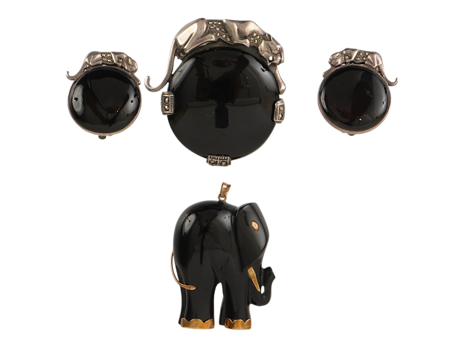 VINTAGE STERLING SILVER AND BLACK ONYX JEWELRY SET: A vintage sterling silver and black onyx two-piece jewelry set, a brooch pendant and a pair of clip-on earrings. Large round black onyx stones topped with a riveted panther motif. Marked 925 on the ba