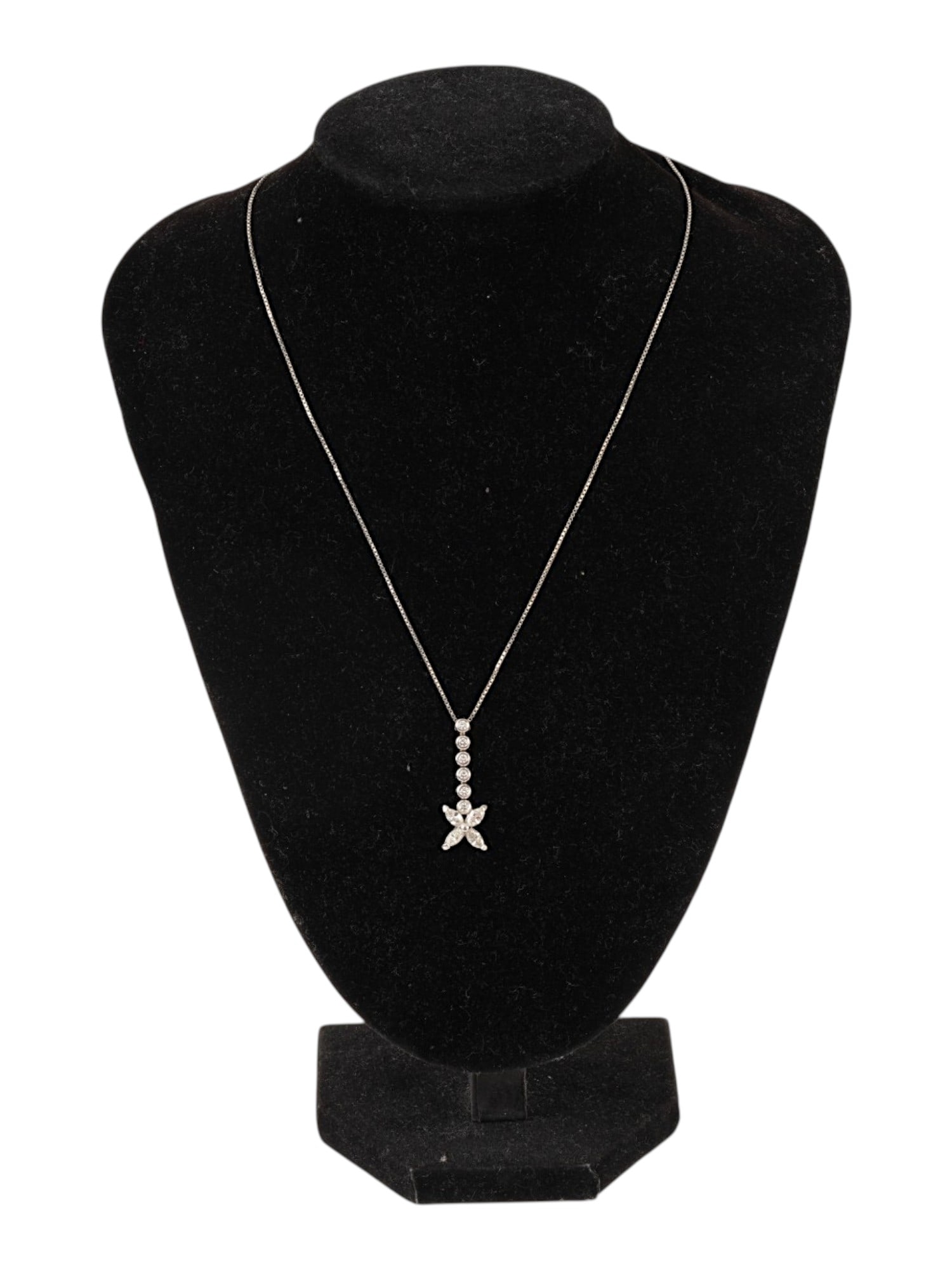14K WHITE GOLD AND 10K DIAMONDS PENDANT NECKLACE: An elegant 14K white gold and 10K diamond pendant necklace. The piece consists of a delicate chain featuring a flower set with marquise-cut diamonds and a row of six round brilliant-cut diamonds. The 