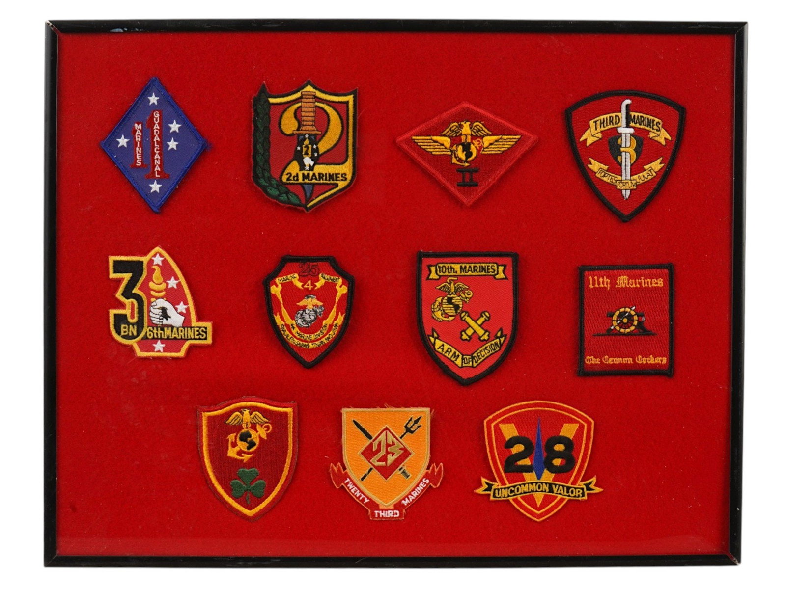 FRAMED COLLECTION OF 11 US MARINE CORPS PATCHES: A framed collection of 11 various patches of US Marine Corps units spanning historical periods such as World War II and the Vietnam War. The set includes emblems of divisions, regiments and specialize
