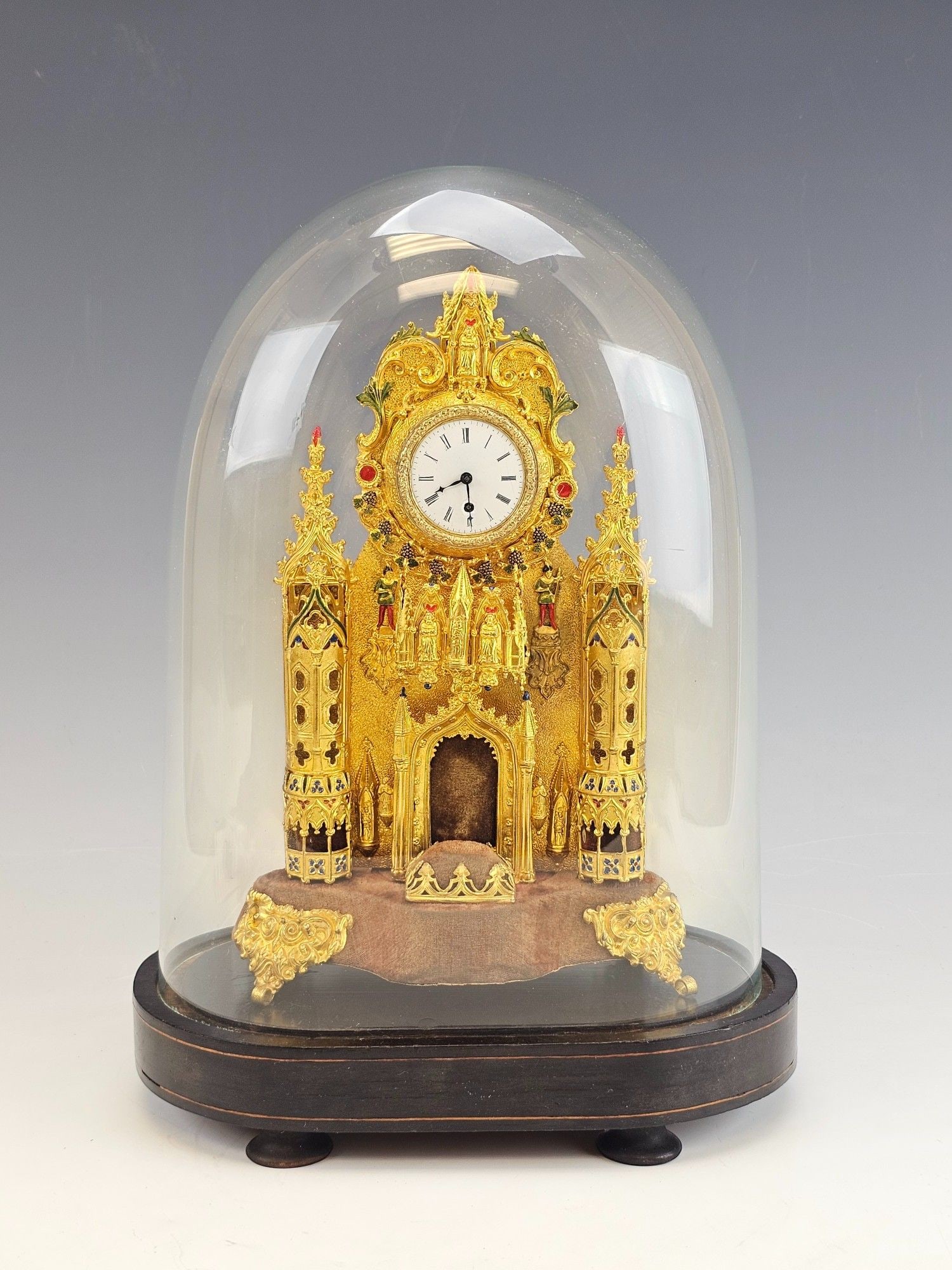 ANTIQUE 19 C EUROPEAN GILT BRONZE ENAMEL MANTEL CLOCK: An antique 19th-century European gilt repousse bronze mantel clock in the form of a Gothic cathedral. Polychrome enamel details. Round white enamel dial with Roman numerals. The piece rests on the ori
