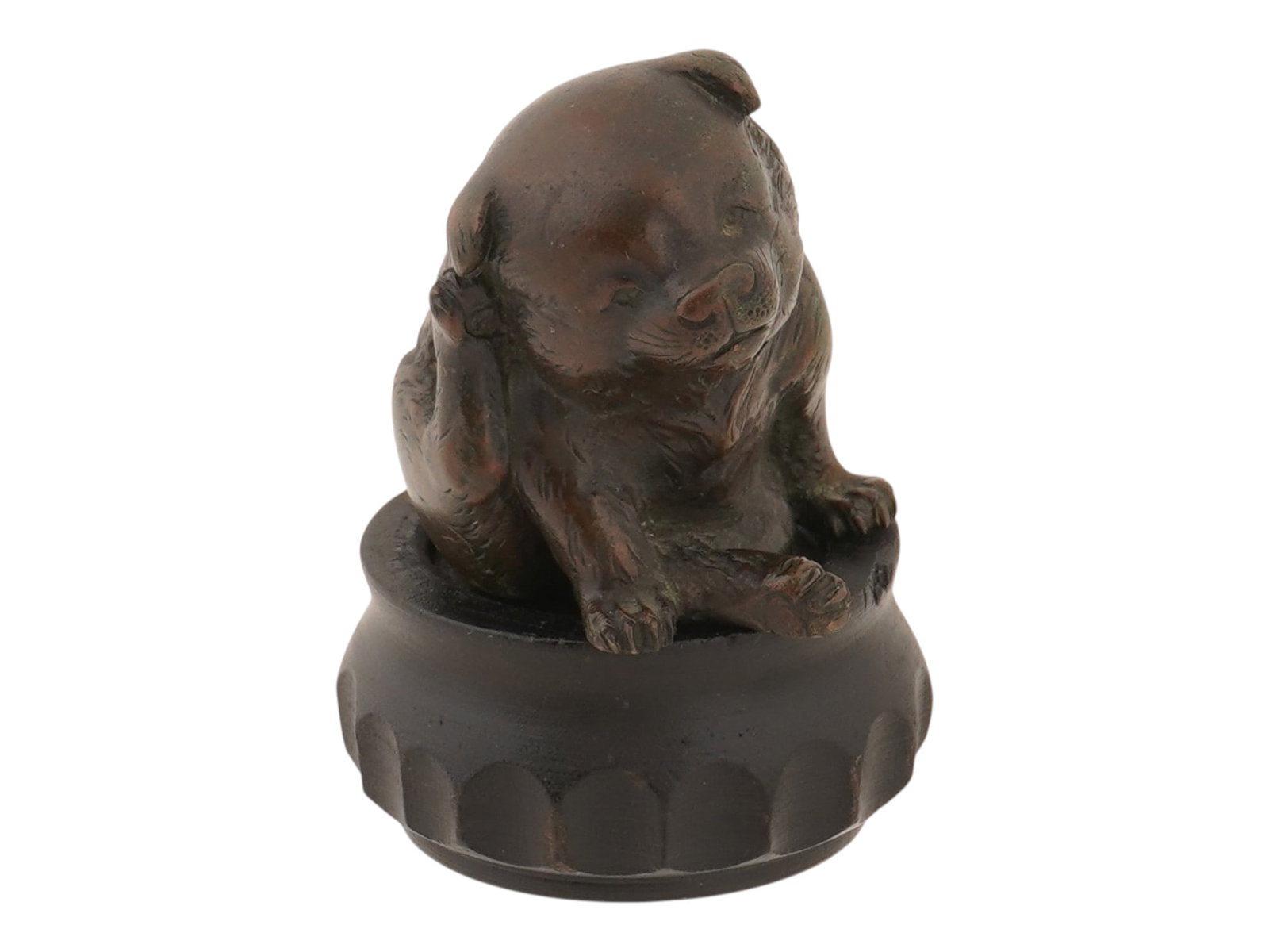 ANTIQUE JAPANESE BRONZE PUPPY OKIMONO FIGURINE: An antique Japanese dark patinated bronze okimono modeled in the shape of a puppy. Marked with an impressed seal on the bottom. Circa the early 20th century. Comes with a carved wood stand. Antique Br