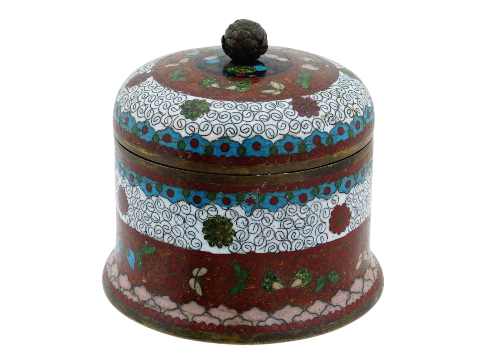 ANTIQUE JAPANESE MEIJI CLOISONNE ENAMEL TRINKET BOX: An antique Japanese brass trinket box. Late Meiji era, before 1912. Lidded bell-shaped piece. Polychrome cloisonne enamel surface in red, white, and blue, stone flake ground, butterfly pattern. Unmark