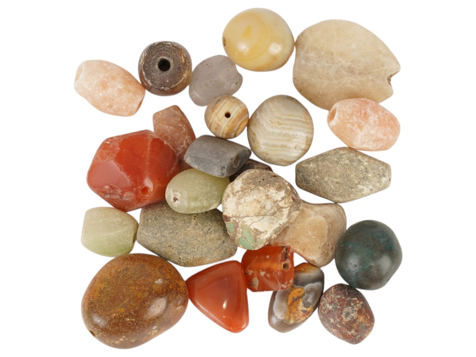 ANCIENT AGATE CARNELIAN STONE BEADS OF VARIOUS SHAPES: A group of ancient agate, carnelian, and related stone beads of various shapes, dating to the 1st millennium BC. Comprising a varied assortment of polished semi-precious stones in natural earth tones.