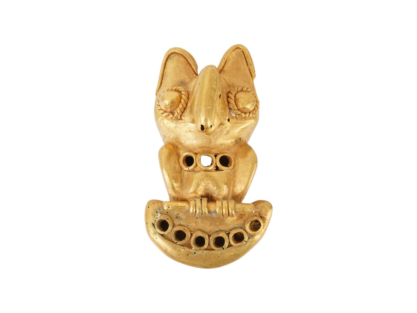 PRE COLOMBIAN TUMBAGA GOLD COPPER ALLOY EFFIGY PENDANT: An ancient Pre Columbian Tairona Tumbaga gold copper alloy figural pendant representing a zoomorphic effigy parrot design. South America, Columbia. The mask is adorned with intricate detailing. Tumbag