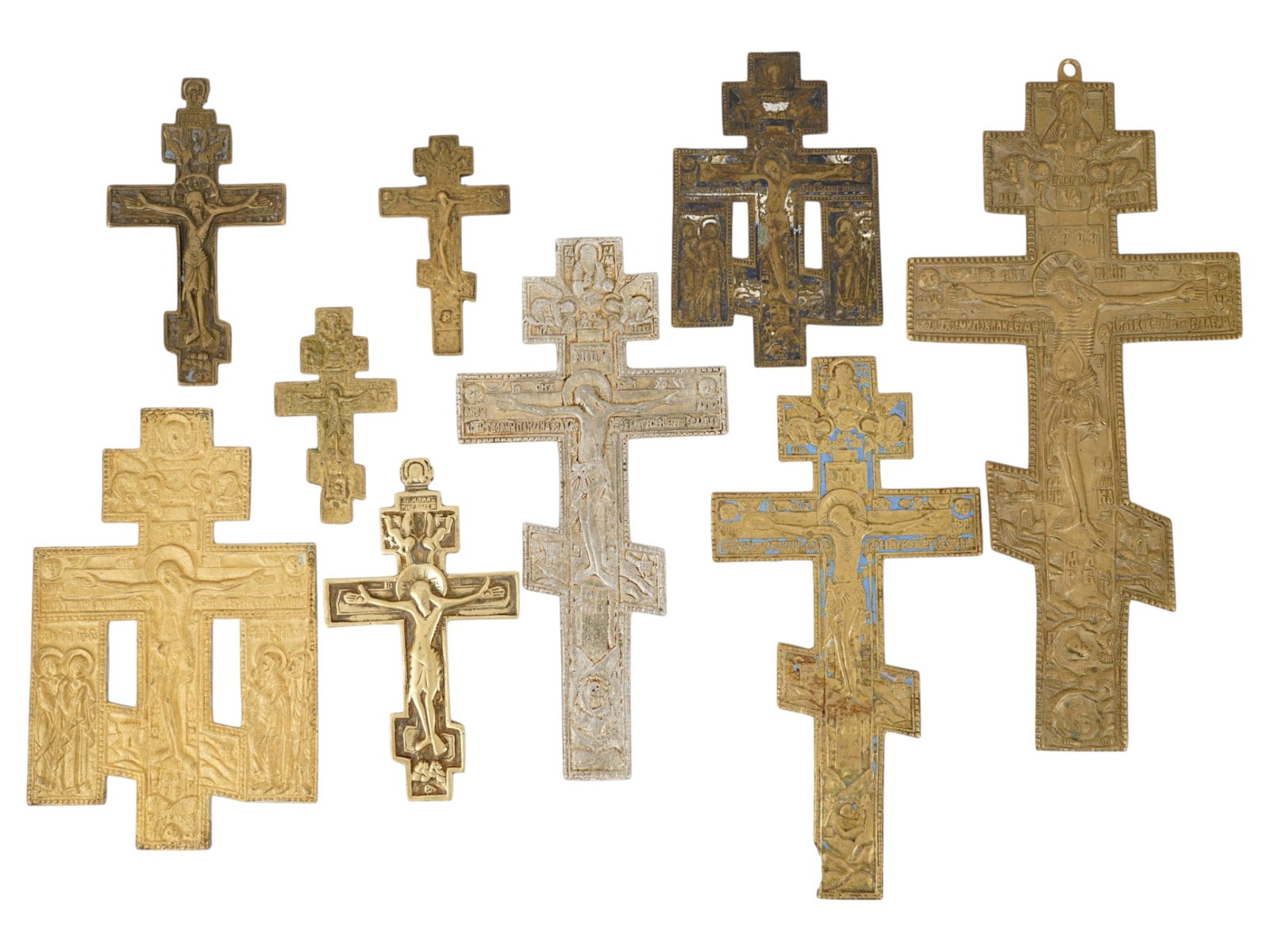 COLLECTION OF RUSSIAN ORTHODOX ENAMEL BRONZE CROSSES: A collection of nine several types of Russian Orthodox crosses, primarily cast from copper alloys like brass and bronze. These pieces typically date from the 18th to the early 20th century. The collec