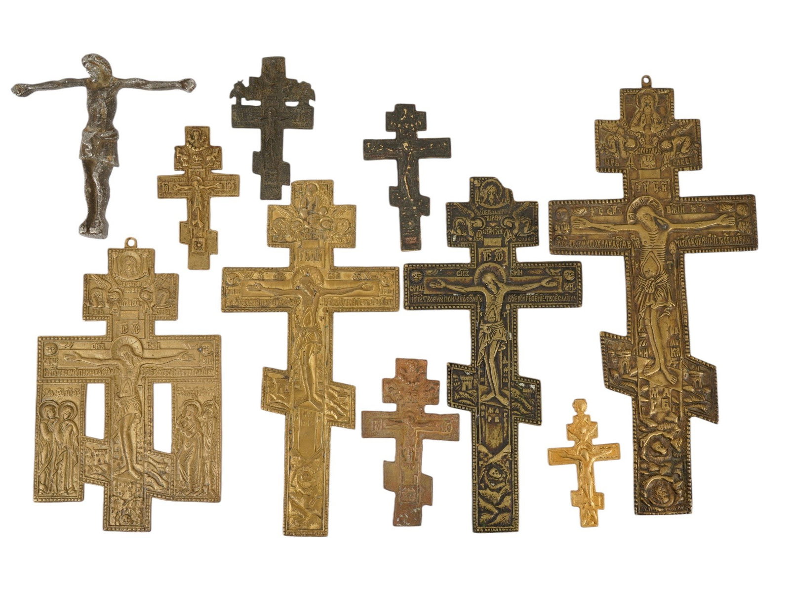 COLLECTION OF RUSSIAN ORTHODOX BRONZE CROSSES: A collection of ten several types of Russian Orthodox crosses, primarily cast from copper alloys like brass and bronze. These pieces typically date from the 18th to the early 20th century. The collect