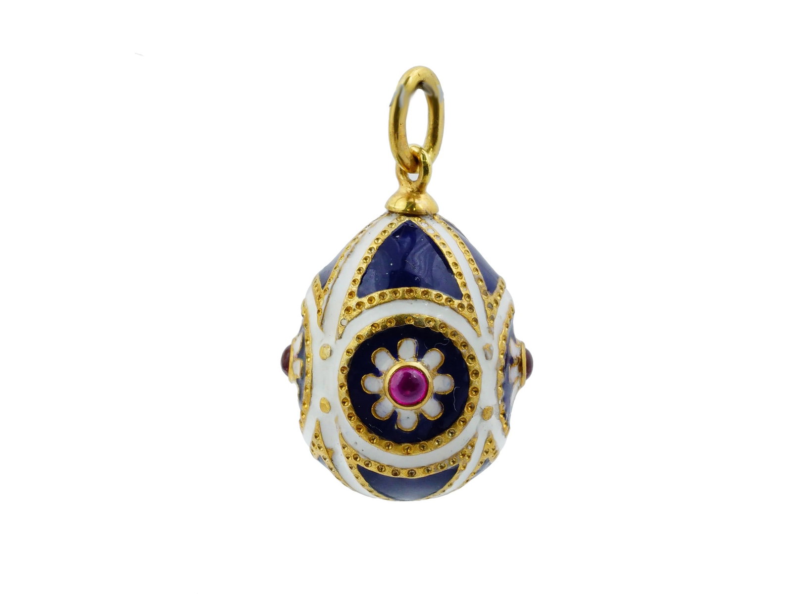 RUSSIAN GEMSTONES SILVER ENAMEL EASTER EGG PENDANT: A Russian Silver and enamel Easter egg pendant featuring four quadrants of translucent cobalt blue enamel over a sunburst guilloche ground. The design is segmented by white enamel bands with beaded bo