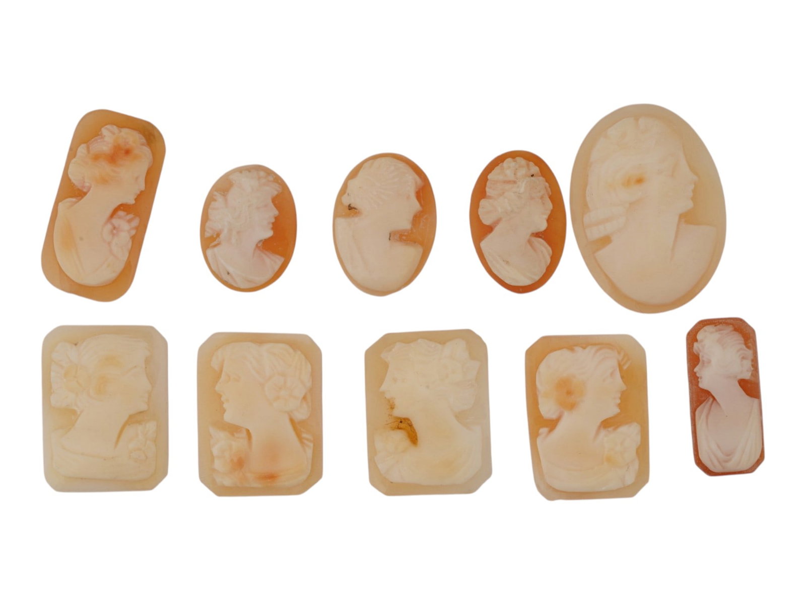 COLLECTION OF 10 VINTAGE CARNELIAN SHELL CAMEO CARVINGS: A collection of 10 vintage carnelian shell cameo carvings. The hand-carved cameos depict classical female portraits and a Roman warrior in a variety of oval, rectangular, and cushion-cut forms. Vintag