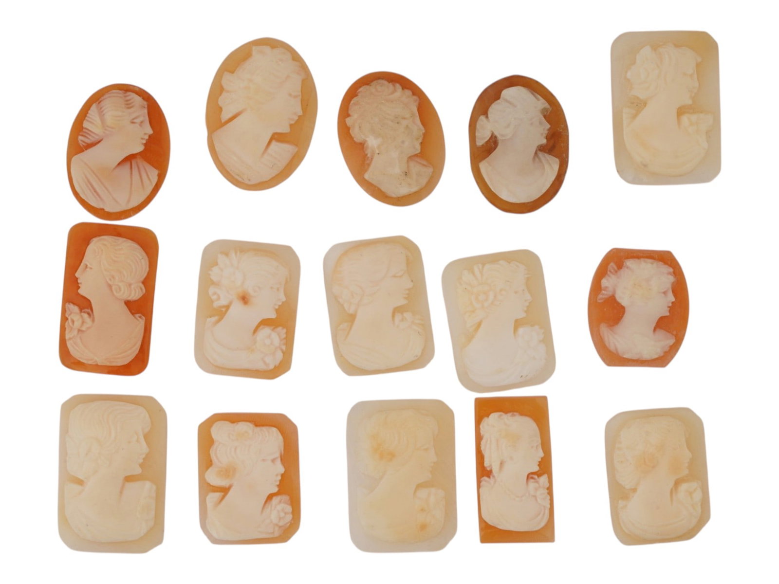 COLLECTION OF FEMALE PORTRAIT CARVED CORAL CAMEOS: A collection of hand carved pink coral cameos. A total of 15 items. Each piece depicts a female profile portrait rendered in high relief. Oval, octagon, and rectangle shape. Collectible Jewelry And Gl