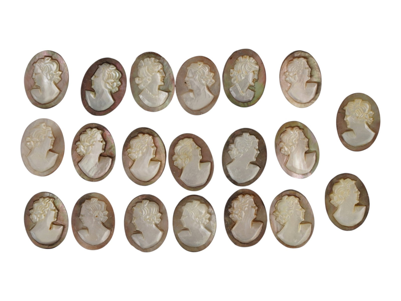 LOT OF CARVED FEMALE PORTRAIT SHELL CAMEO MEDALLIONS: A collection of twenty hand carved shell cameo medallions. The pieces depict a female profile portrait rendered in high relief in the Victorian and Roman manners. Each cameo is fashioned in a distinct