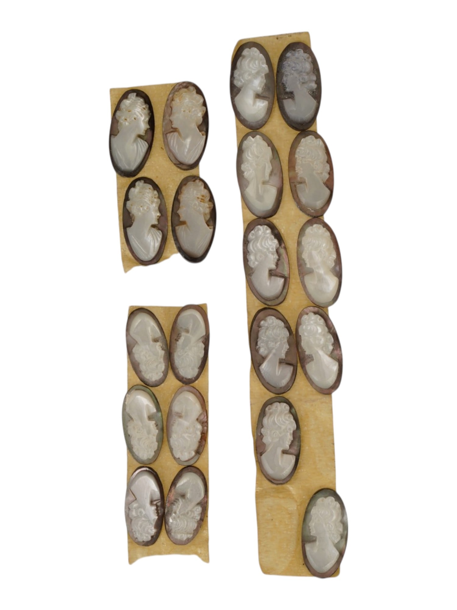 LOT OF CARVED FEMALE PORTRAIT SHELL CAMEO MEDALLIONS: A collection of twenty hand carved shell cameo medallions. The pieces depict a female profile portrait rendered in high relief in the Victorian manner. Each cameo is fashioned in a distinctive oval fo