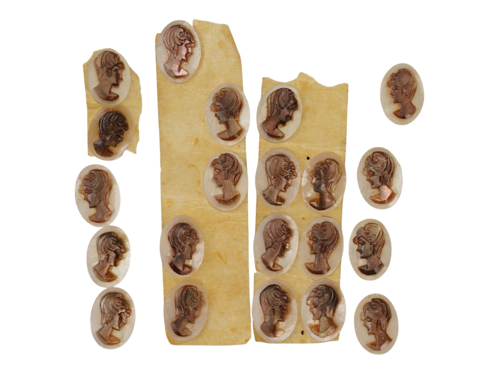 LOT OF CARVED FEMALE PORTRAIT SHELL CAMEO MEDALLIONS: A collection of twenty one hand carved shell cameo medallions. The pieces depict a female profile portrait rendered in high relief in the Victorian manner. Each cameo is fashioned in a distinctive ova
