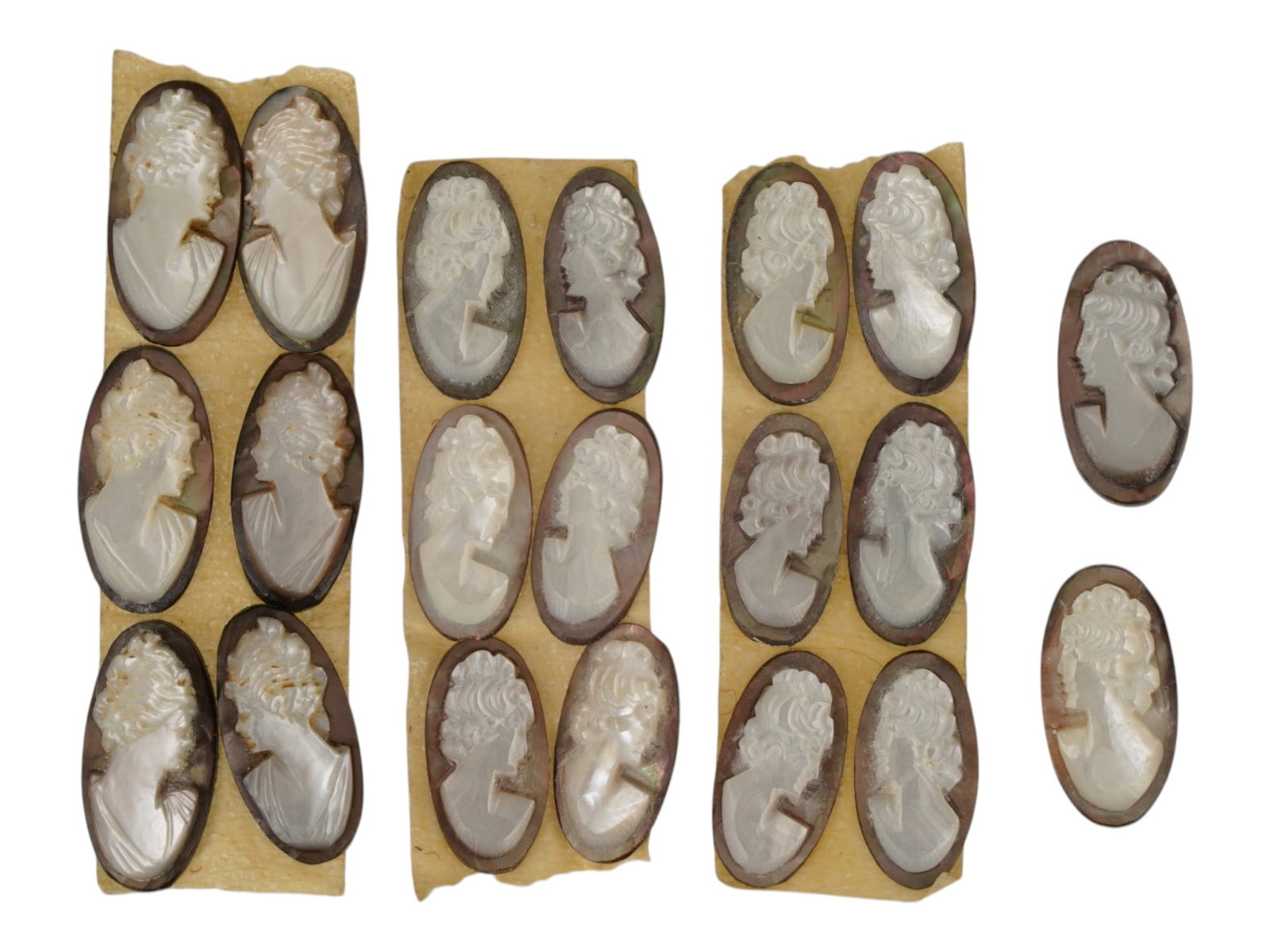 COLLECTION OF FEMALE PORTRAIT CARVED SHELL CAMEOS: A collection of hand carved conch shell cameos. A total of 20 items. Each piece features female profile portraits rendered in high relief. Oval shape. Collectible Jewelry And Glyptic Art, Sculpture. T