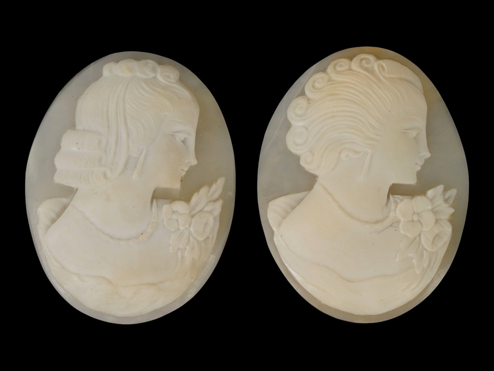 LOT OF CARVED FEMALE PORTRAIT SHELL CAMEO MEDALLIONS: A lot of two hand carved shell cameo medallions. The pieces depict a female profile portrait rendered in high relief in the Victorian and Roman manners. Each cameo is fashioned in a distinctive oval f