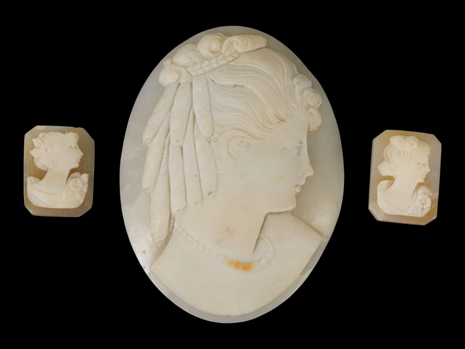 LOT OF CARVED FEMALE PORTRAIT SHELL CAMEO MEDALLIONS: A collection of three hand carved shell cameo medallions. The pieces depict a female profile portrait rendered in high relief in the Victorian and Roman manners. Each cameo is fashioned in distinctive
